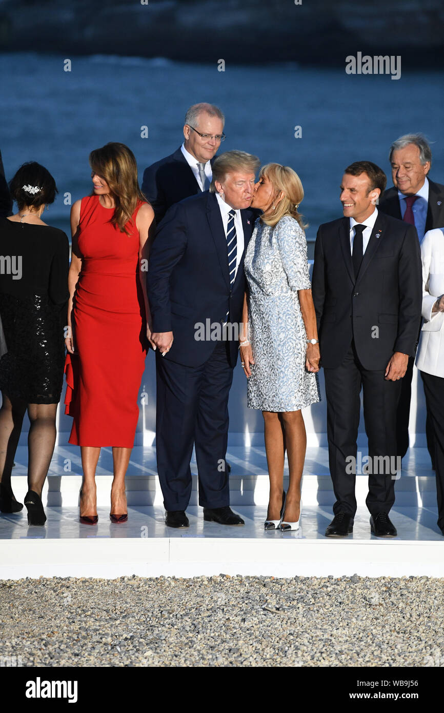 Le président français, Emmanuel Macron regarde sa femme Brigitte Macron baisers Président Donald Trump comme il se tient avec la première dame Melania Trump comme ils inscrivez-vous d'autres dirigeants du monde pour la photo de famille au sommet du G7 à Biarritz, France. Banque D'Images