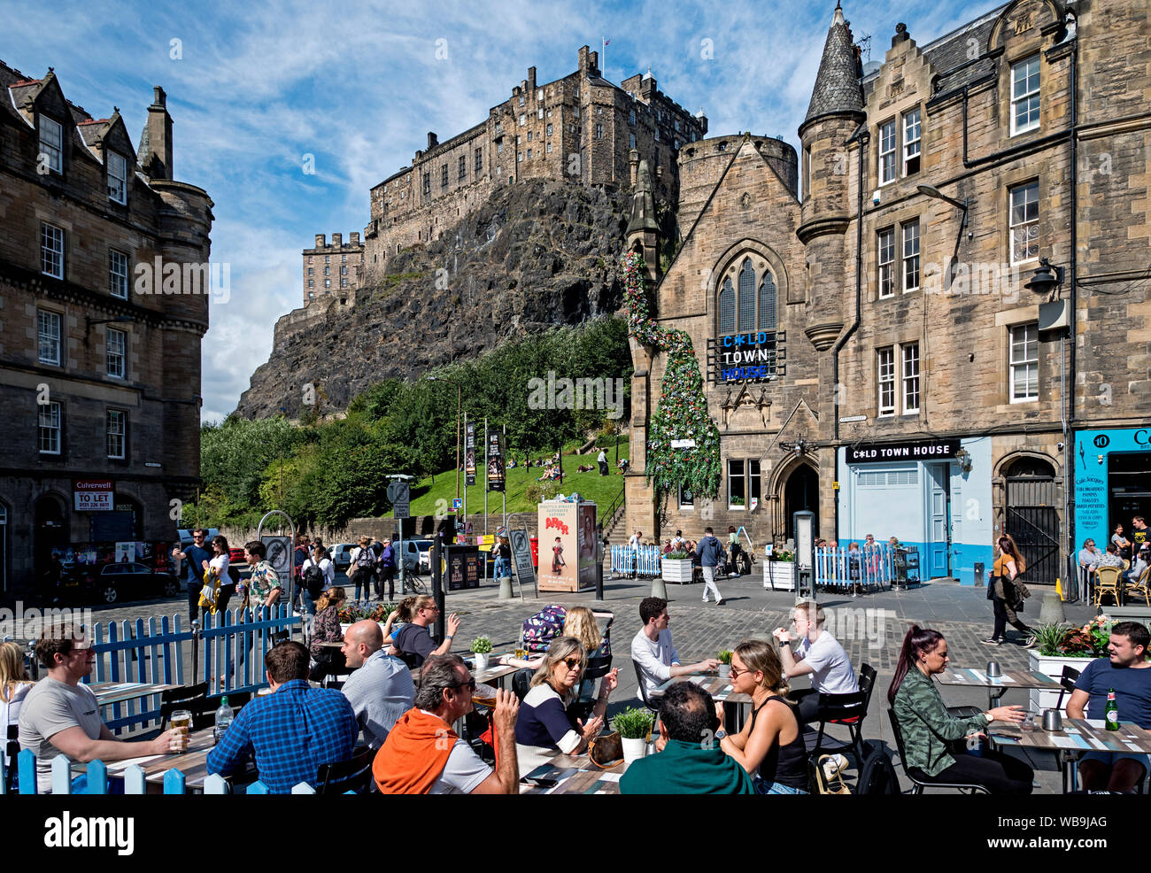 Diners manger dehors dans le Grassmarket avec vue sur le château d'Édimbourg à l'arrière-plan. Banque D'Images