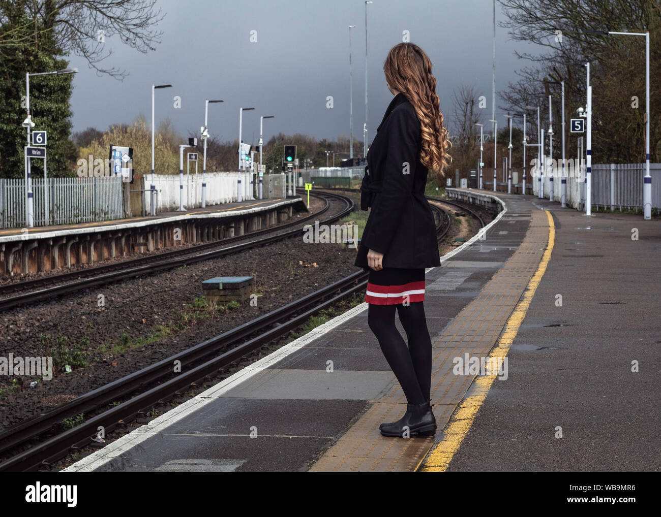 Fille attendant le train à la gare. Banque D'Images