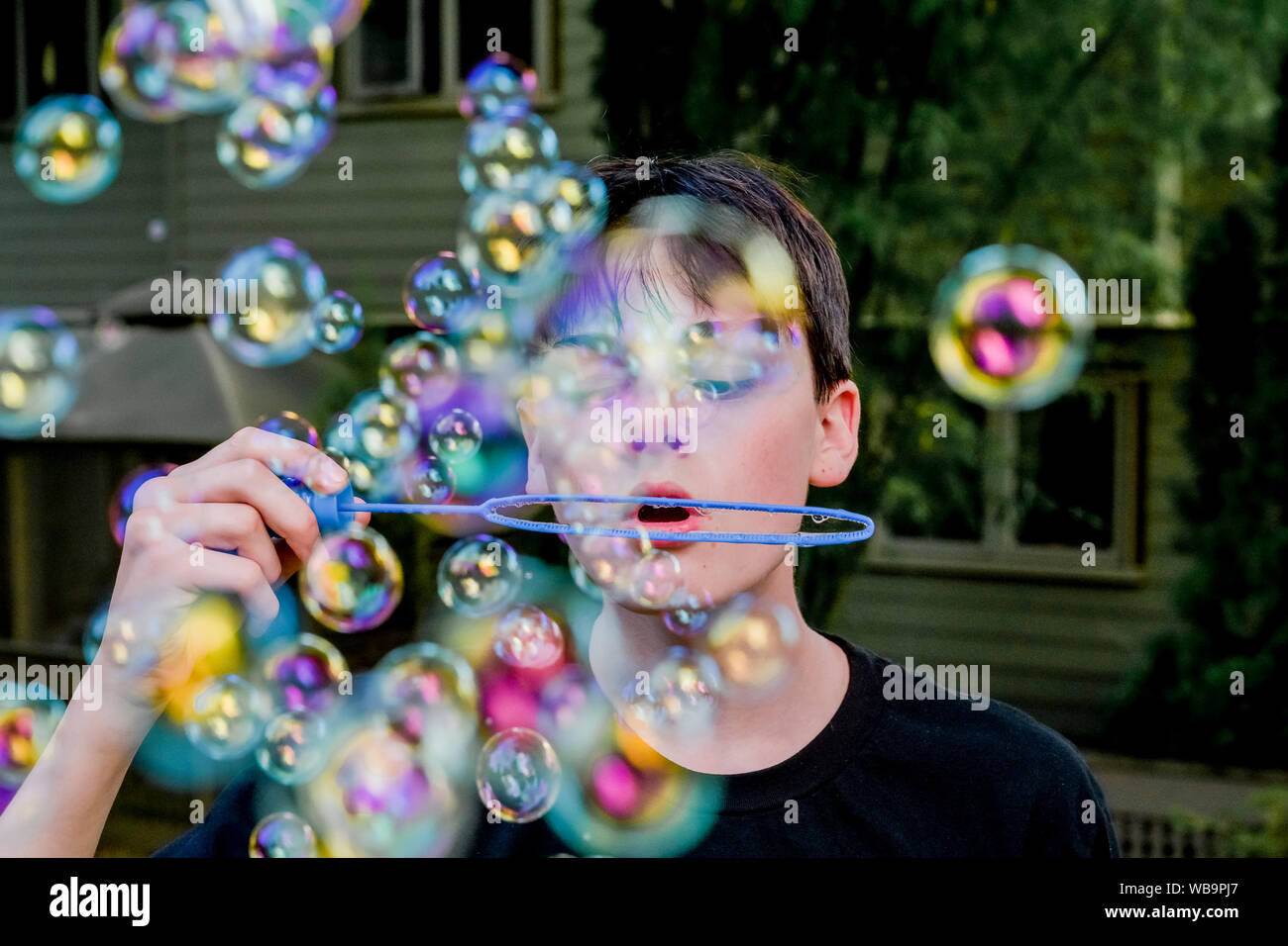 Teenage boy blowing soap bubbles Banque D'Images