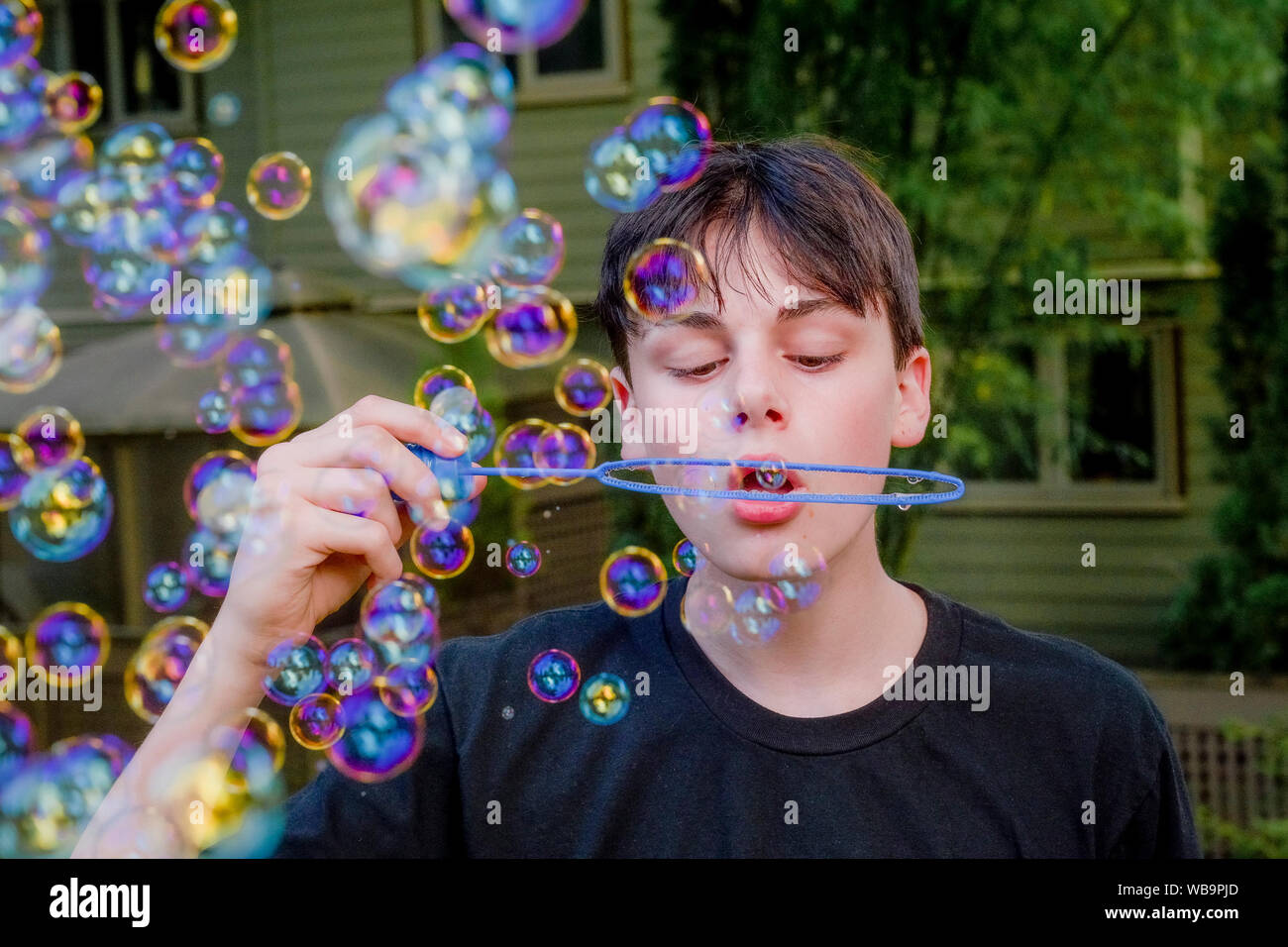Teenage boy blowing soap bubbles Banque D'Images