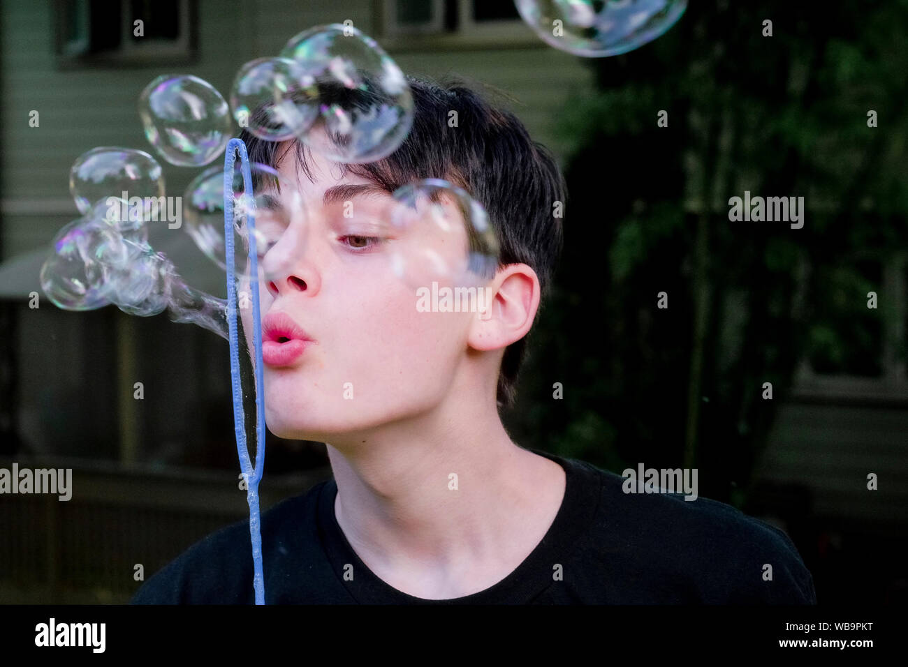 Teenage boy blowing soap bubbles Banque D'Images