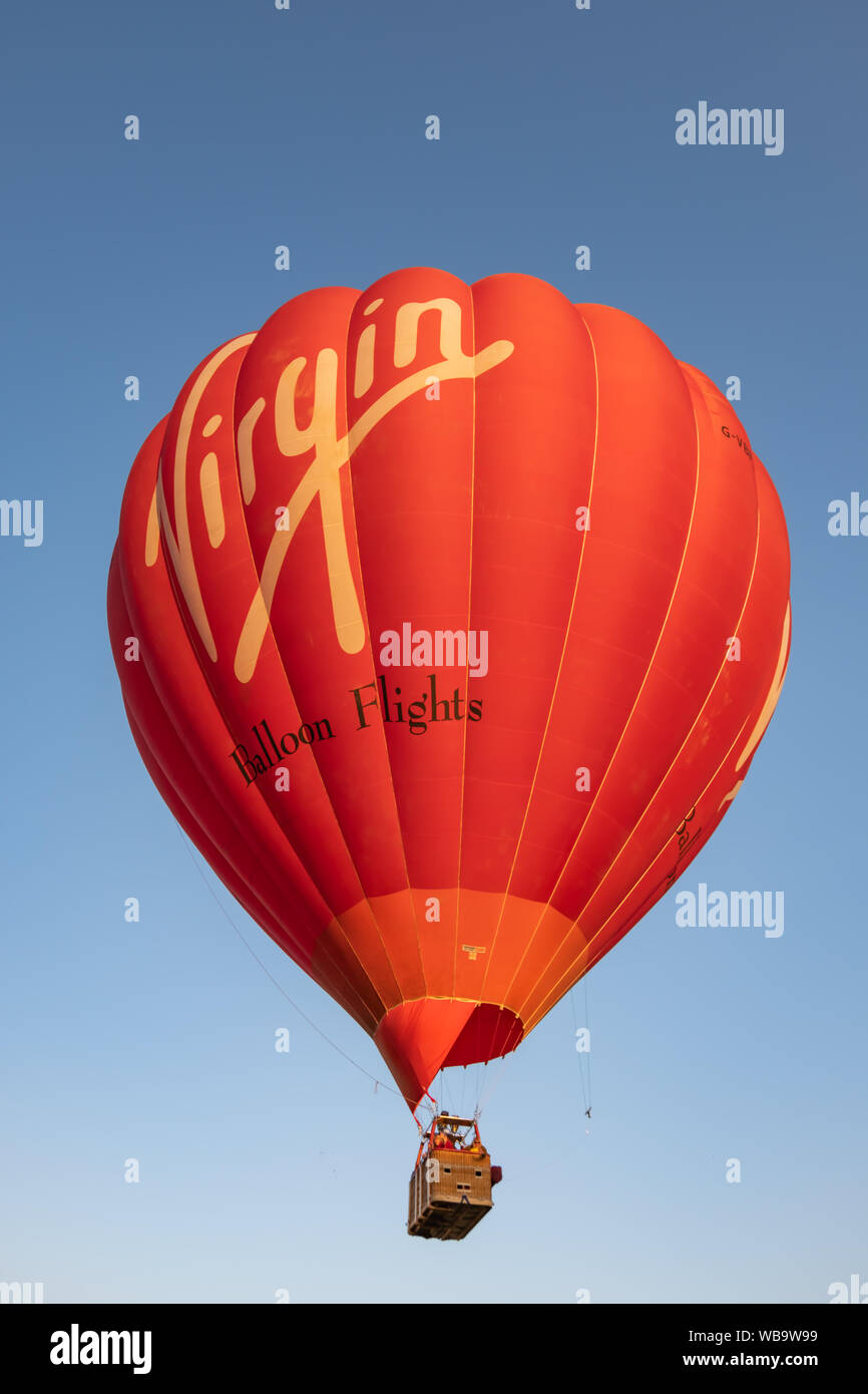 Strathaven, Ecosse, Royaume-Uni. Août 25, 2019. Un ballon à air chaud avec le logo Virgin sur le côté en vol au Strathaven Montgolfières qui fête cette année son 20e anniversaire et est tenu à l'primé Strathaven Park.Le festival attire les pilotes et visiteurs de tous les coins de l'Europe avec plus de 25 000 spectateurs présents au cours de la fin de semaine. Credit : Skully/Alamy Live News Banque D'Images