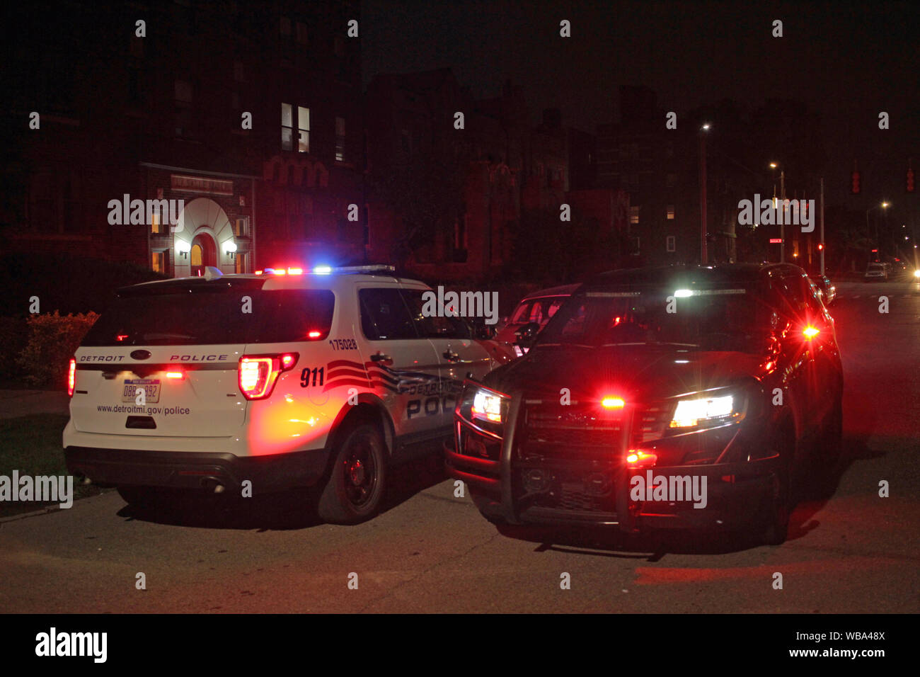 Une paire de Detroit de véhicules de police garés dans rue le soir avec l'éclairage de secours de clignoter. Banque D'Images