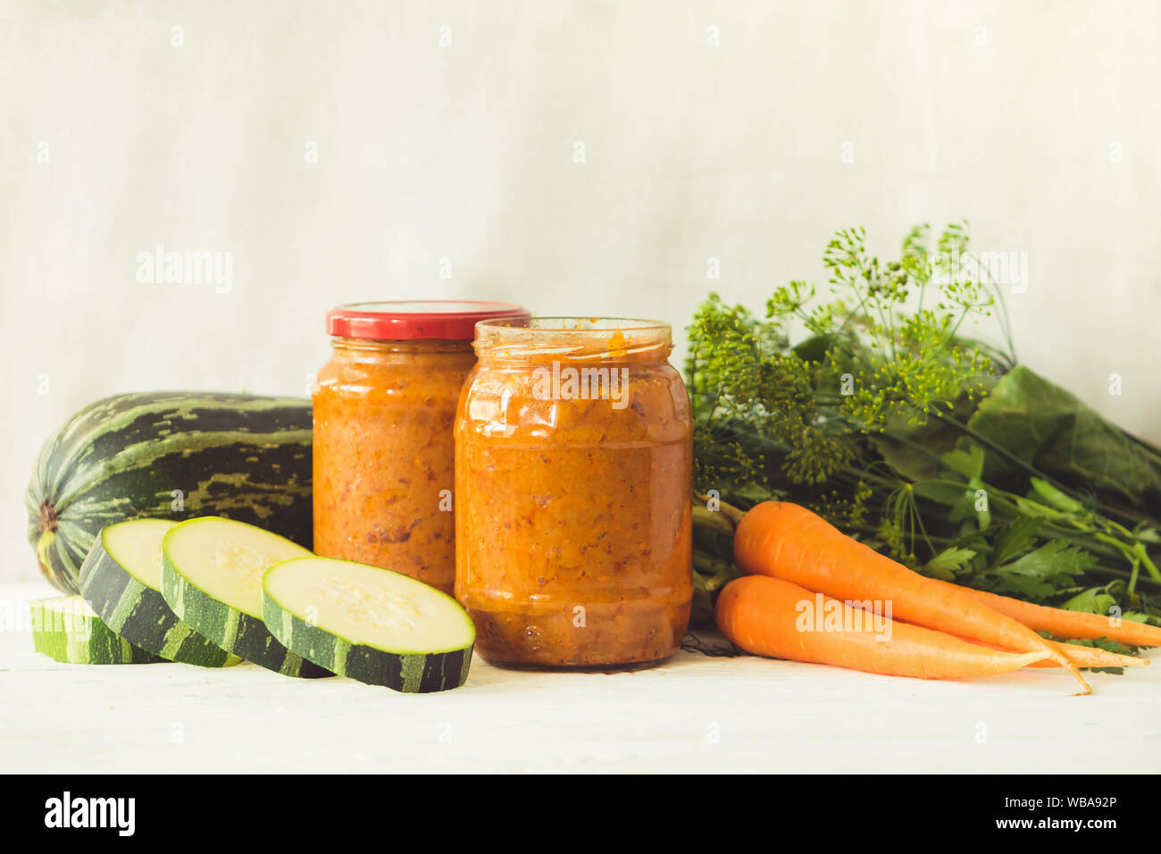 La mise en conserve des légumes fermentés conservés divers courgettes carottes en pots sur une table un fond clair. Traitement de l'automne culture d'été. Fo en conserve Banque D'Images