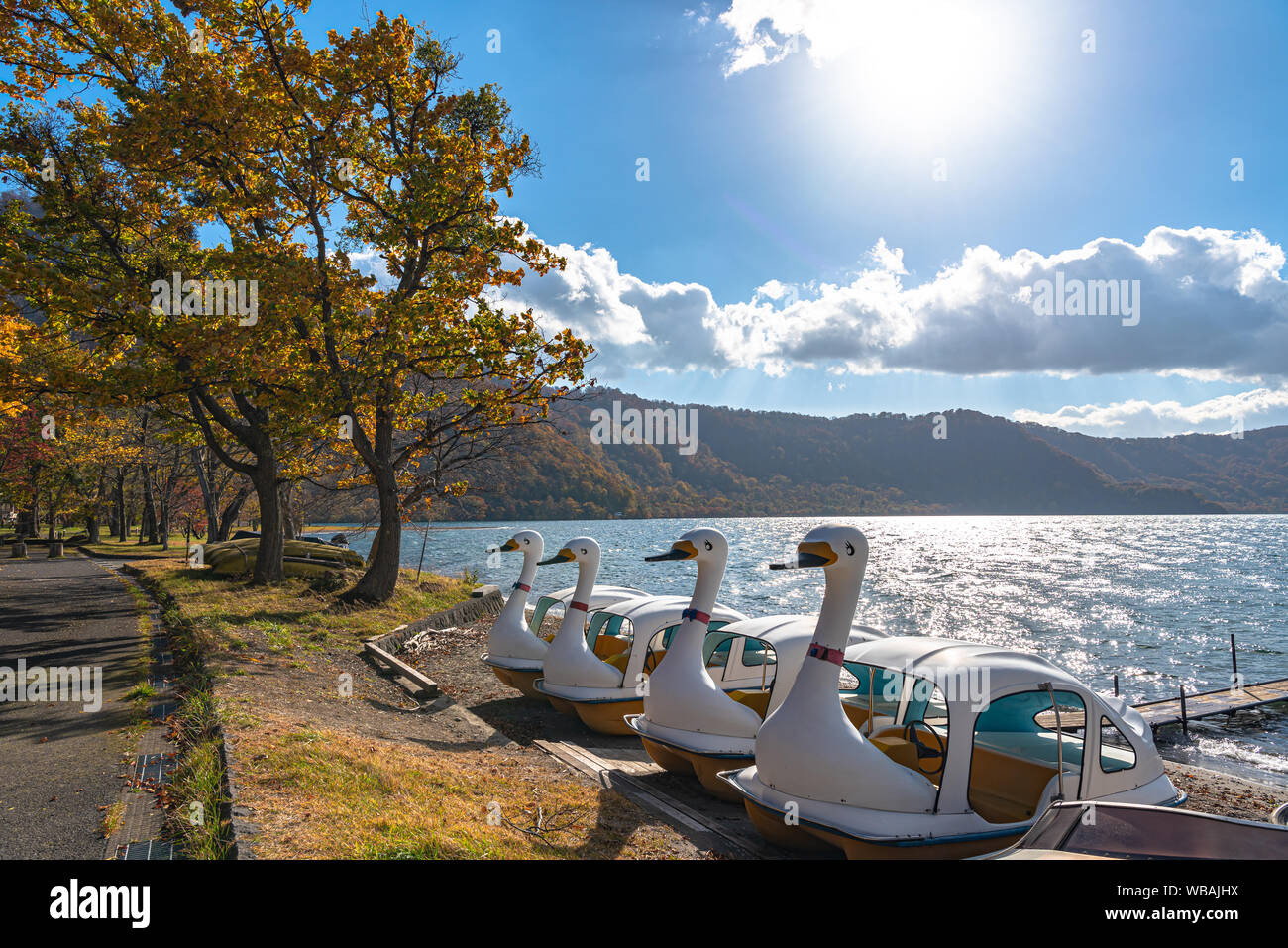 Beau feuillage d'automne paysages paysages du Lac Towada en journée ensoleillée. Vue depuis la jetée du lac Swan, bateaux dans l'avant-plan, ciel clair, Blue Water Banque D'Images