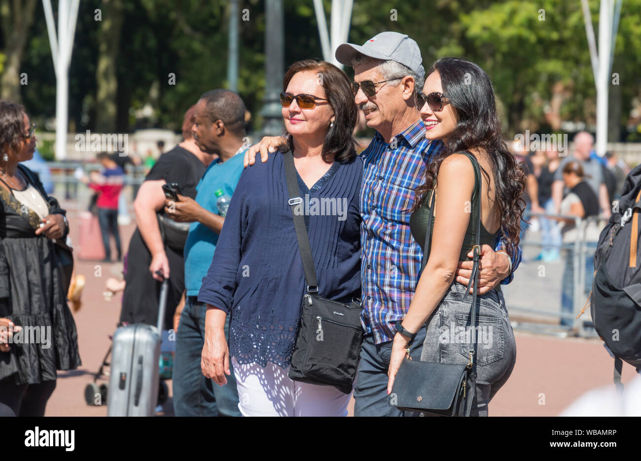 Groupe de touristes posant pour une photo en été dans le centre de Londres, Angleterre, Royaume-Uni. Banque D'Images