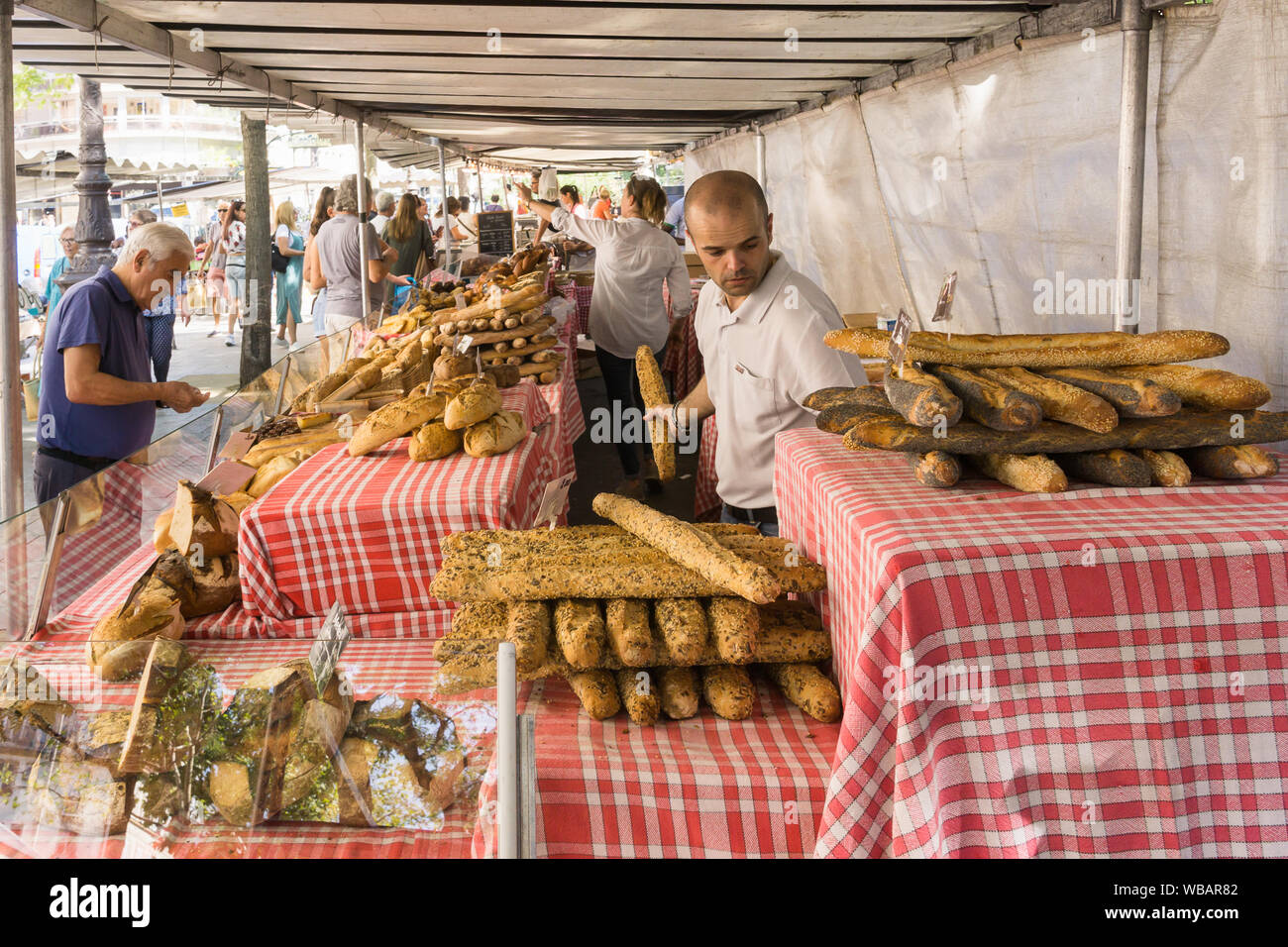 Paris baguette - marché de vente du vendeur du marché et d'autres baguette de pain à un marché de Paris, France, Europe. Banque D'Images