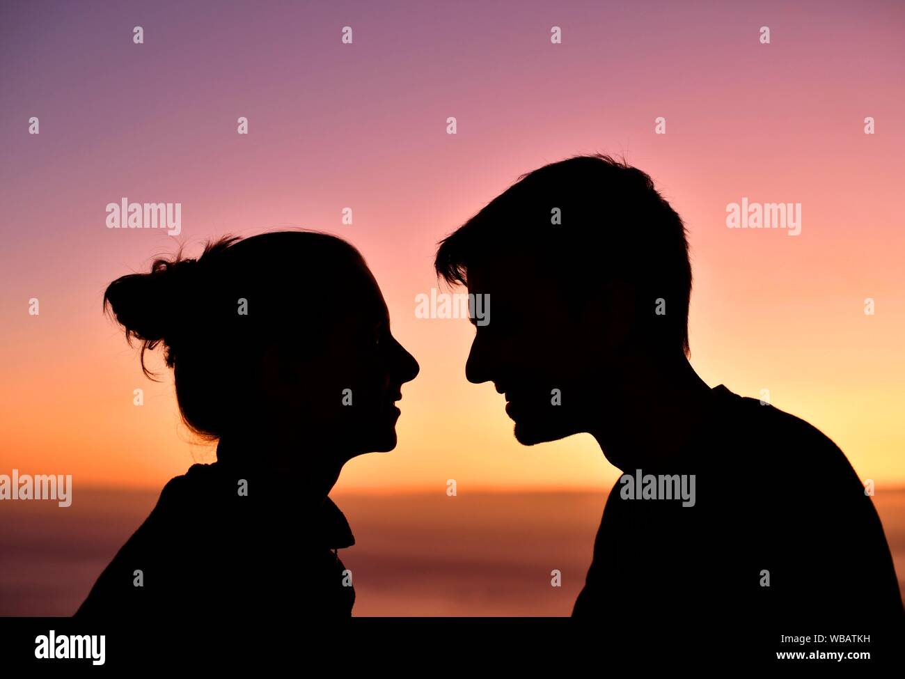Jeune couple, amoureux, silhouette, face-à-face, au coucher du soleil, l'île de Madère, Portugal Banque D'Images