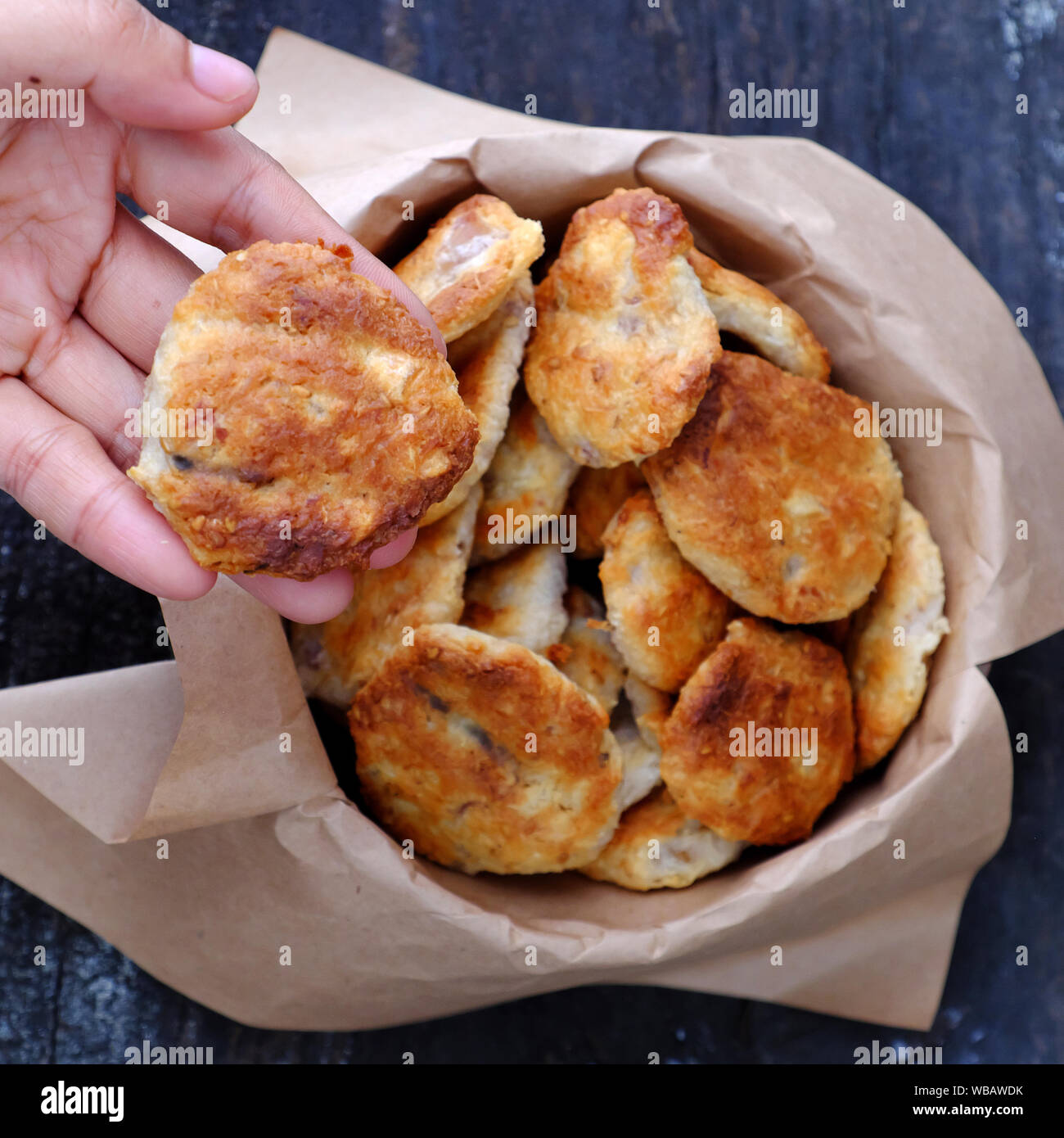 Close up femme choisir une pâtisserie, des gâteaux pour le goûter, la noix de coco tartes de manioc cuit sur fond de toile. Banque D'Images