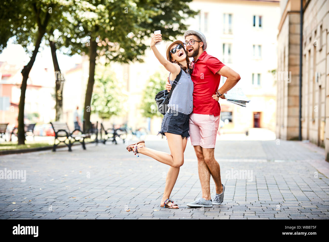 Jeune couple en tenant ensemble selfies en vacances dans la ville Banque D'Images