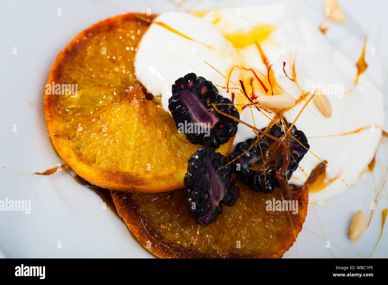 Délicieux dessert des oranges caramélisées, mûres et yogourt Banque D'Images