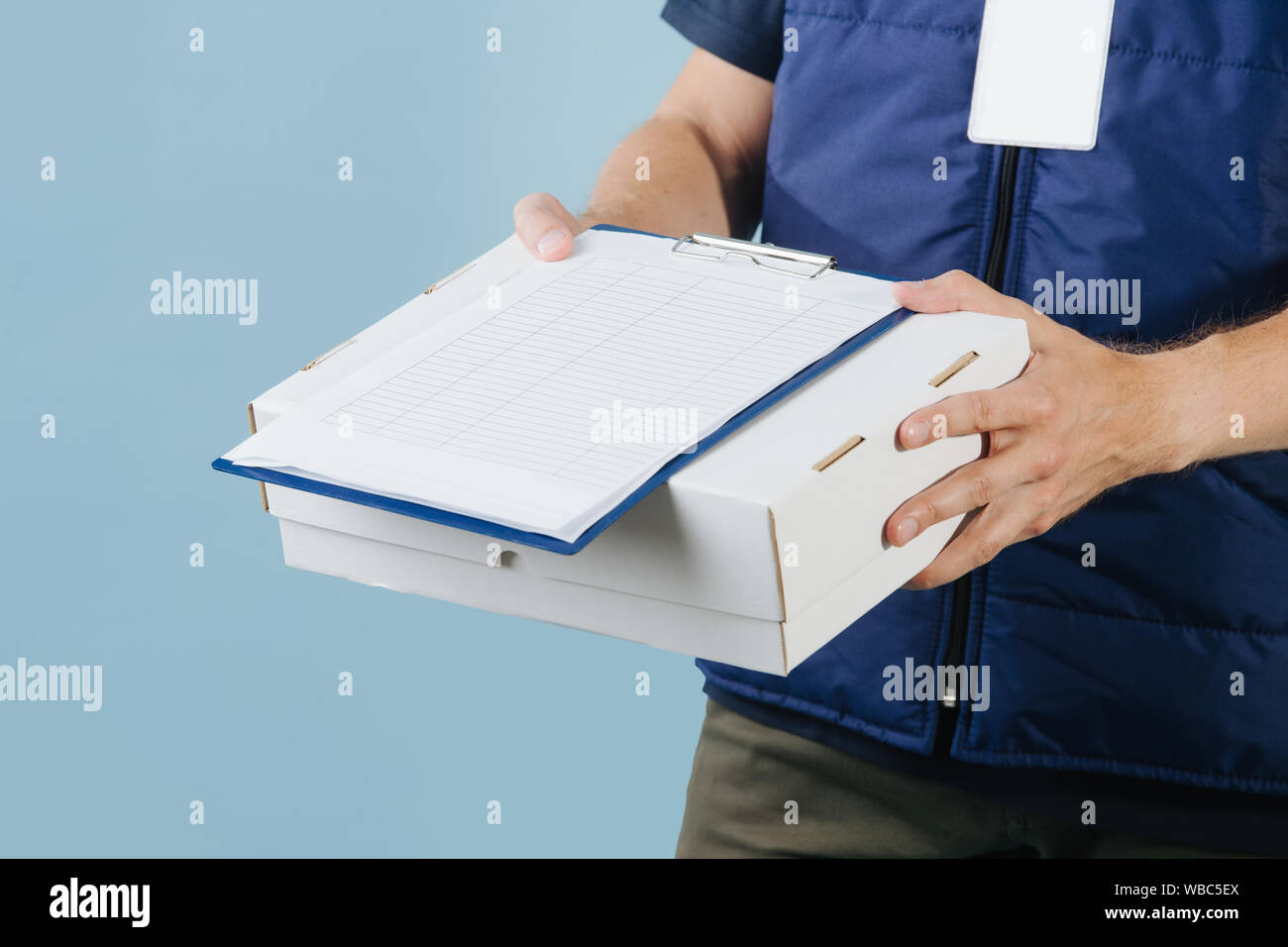 La livraison du courrier fort, offrant à signer un formulaire papier, qui  se trouve sur le dessus de la boîte Photo Stock - Alamy