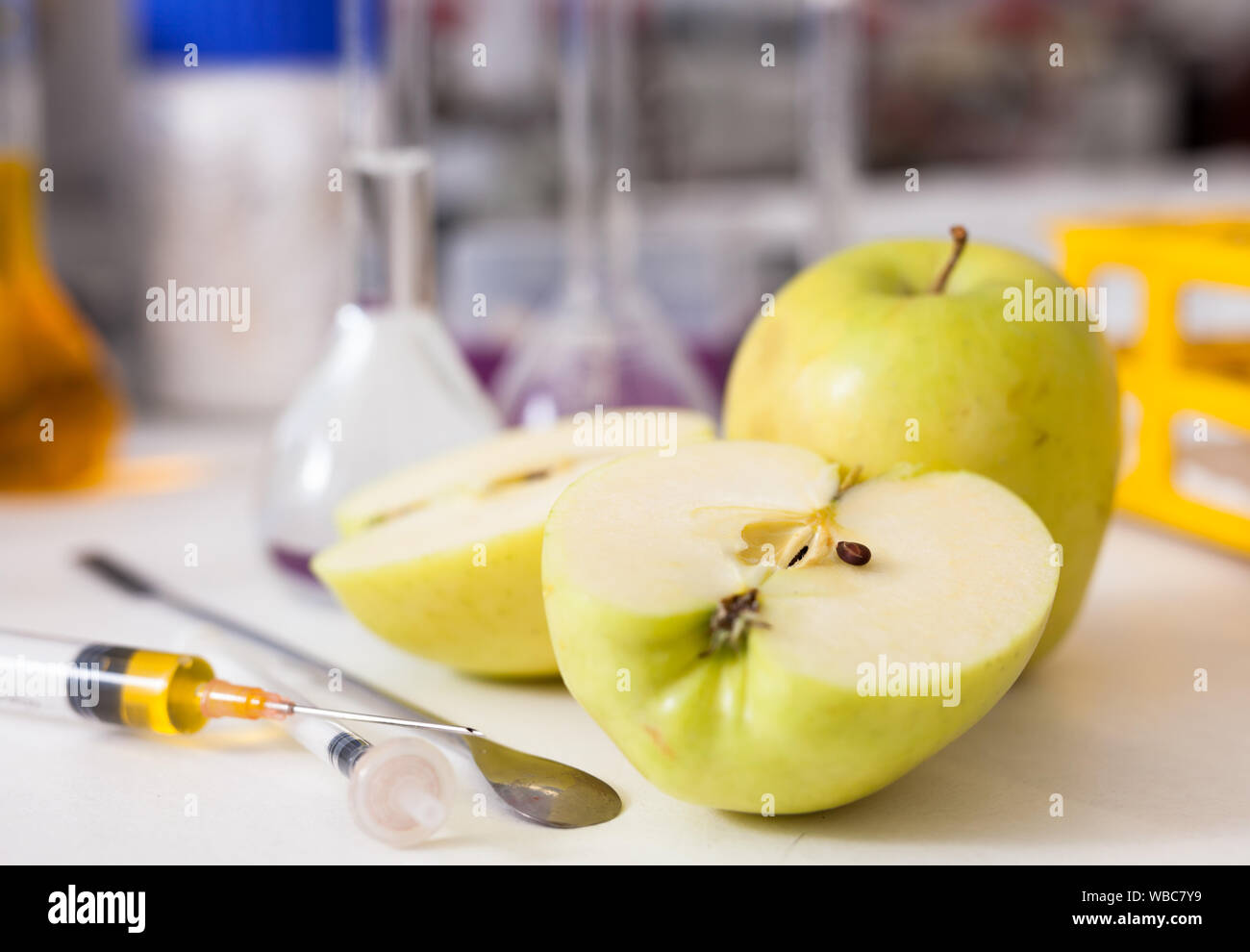 Le contrôle de la qualité des produits agricoles. Les pommes biologiques mûrs sur fond avec des outils et équipements de laboratoire Banque D'Images