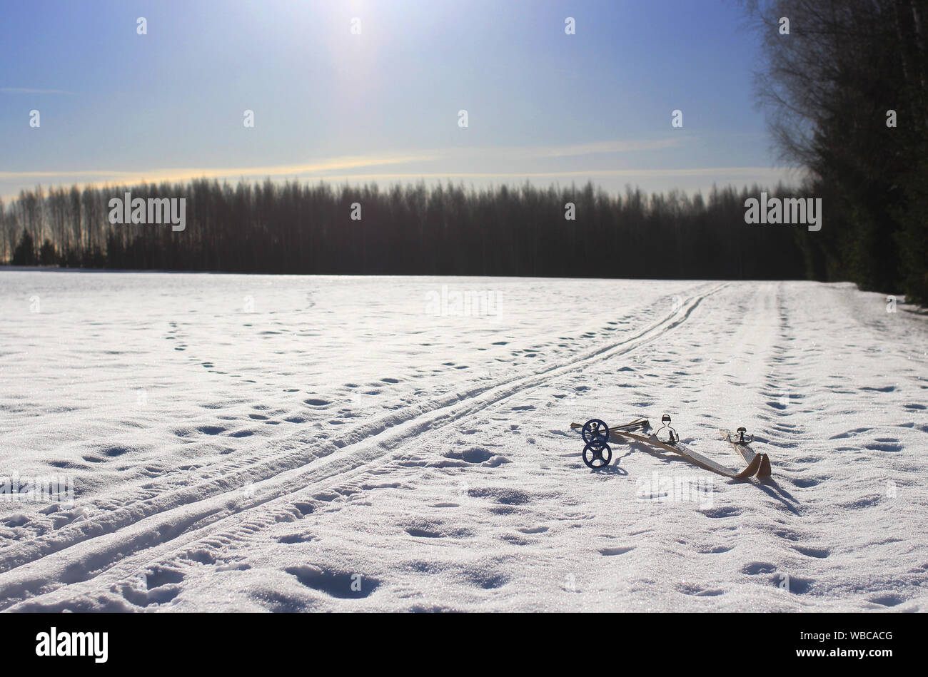 Croix de bois vieux skis de fond et une piste de ski enneigées vide avec ciel bleu clair Banque D'Images