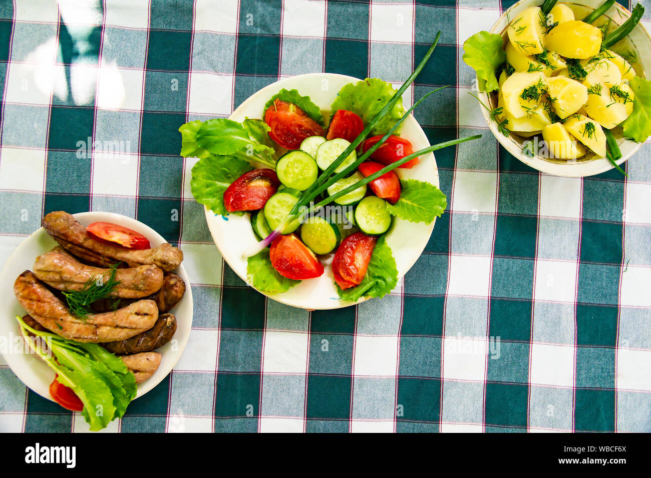 Sur la table des plats - légumes, pommes de terre, saucisses bavaroises. L'arrière-plan. Banque D'Images
