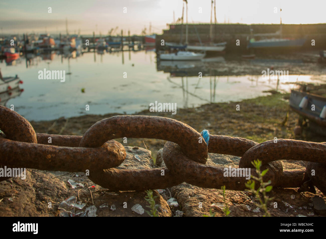 Bateaux dans le port de Newlyn avec chaîne de fer rouillé en premier plan Banque D'Images