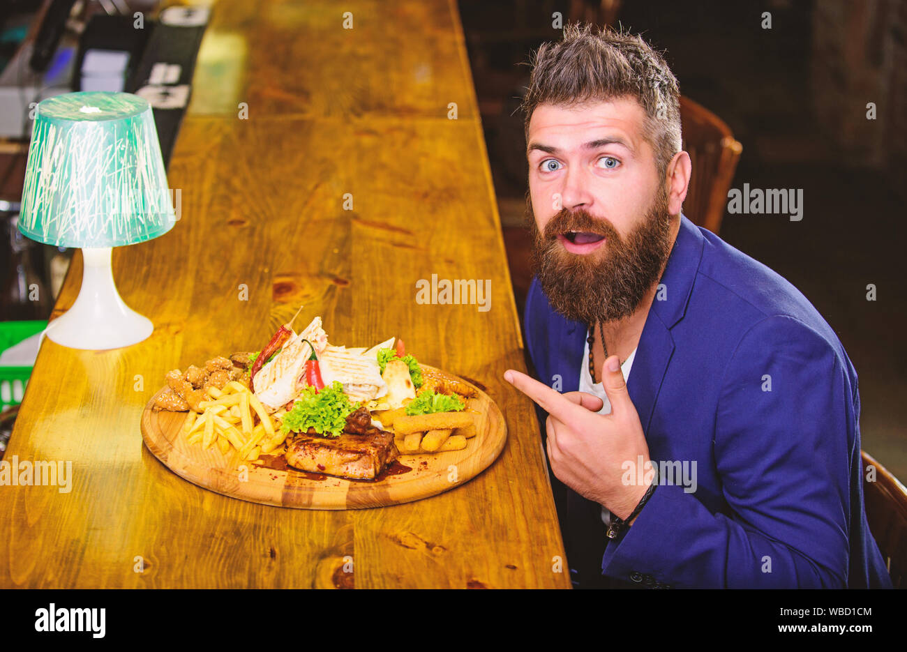 Vous pourrez vous détendre après une dure journée de travail. Woman costume formel s'asseoir à comptoir bar. L'homme a reçu de pommes de terre frites repas avec viande et poisson, lavash. Profitez de repas. Il méritent de délicieux repas. Des calories. Banque D'Images