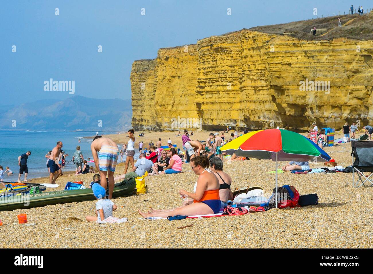 Burton Bradstock, Dorset, UK. 26 août 2019. Météo britannique. Les baigneurs et les vacanciers affluent à la plage à Burton Bradstock à Dorset pour un jour de températures chaudes et soleil voilé sur bank holiday lundi après un début de matinée brumeuse. Crédit photo : Graham Hunt/Alamy Live News Banque D'Images