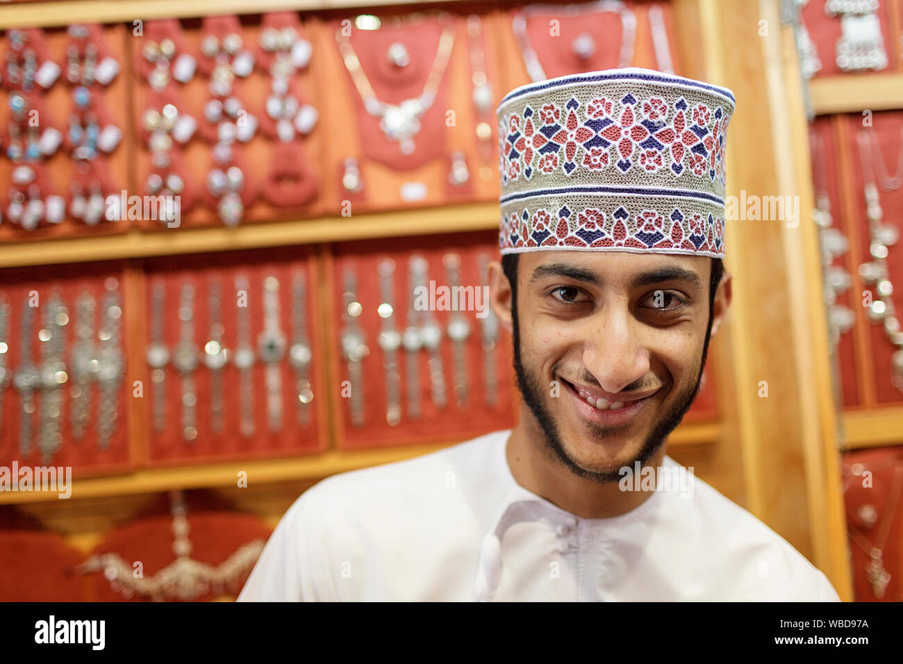 Portrait de jeune homme en vêtements traditionnels brodés portant la vente de bijoux, Nizwa, Sultanat d'Oman Banque D'Images