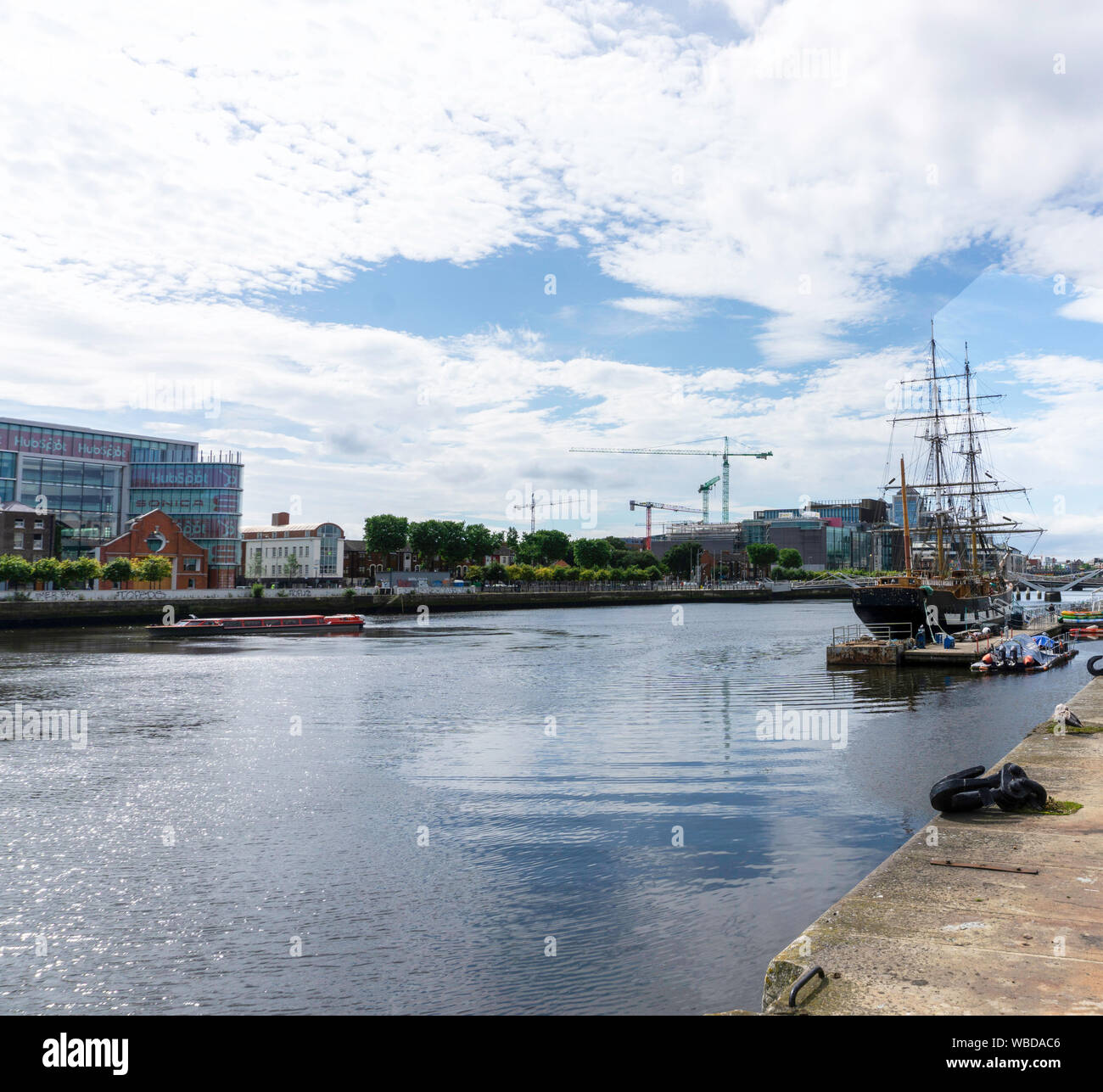 . Une scène sur la Liffey avec le Jeanie Johnston replica famine ship sur la droite, un bateau d'excursion rouge sur une visite guidée. Banque D'Images