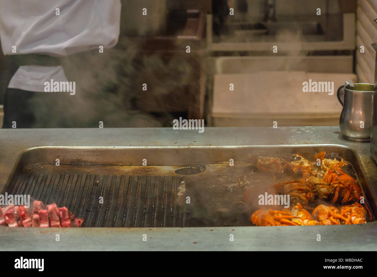 Les écrevisses délicieux grillés et des côtes sur cuisinière électrique avec de la fumée Banque D'Images