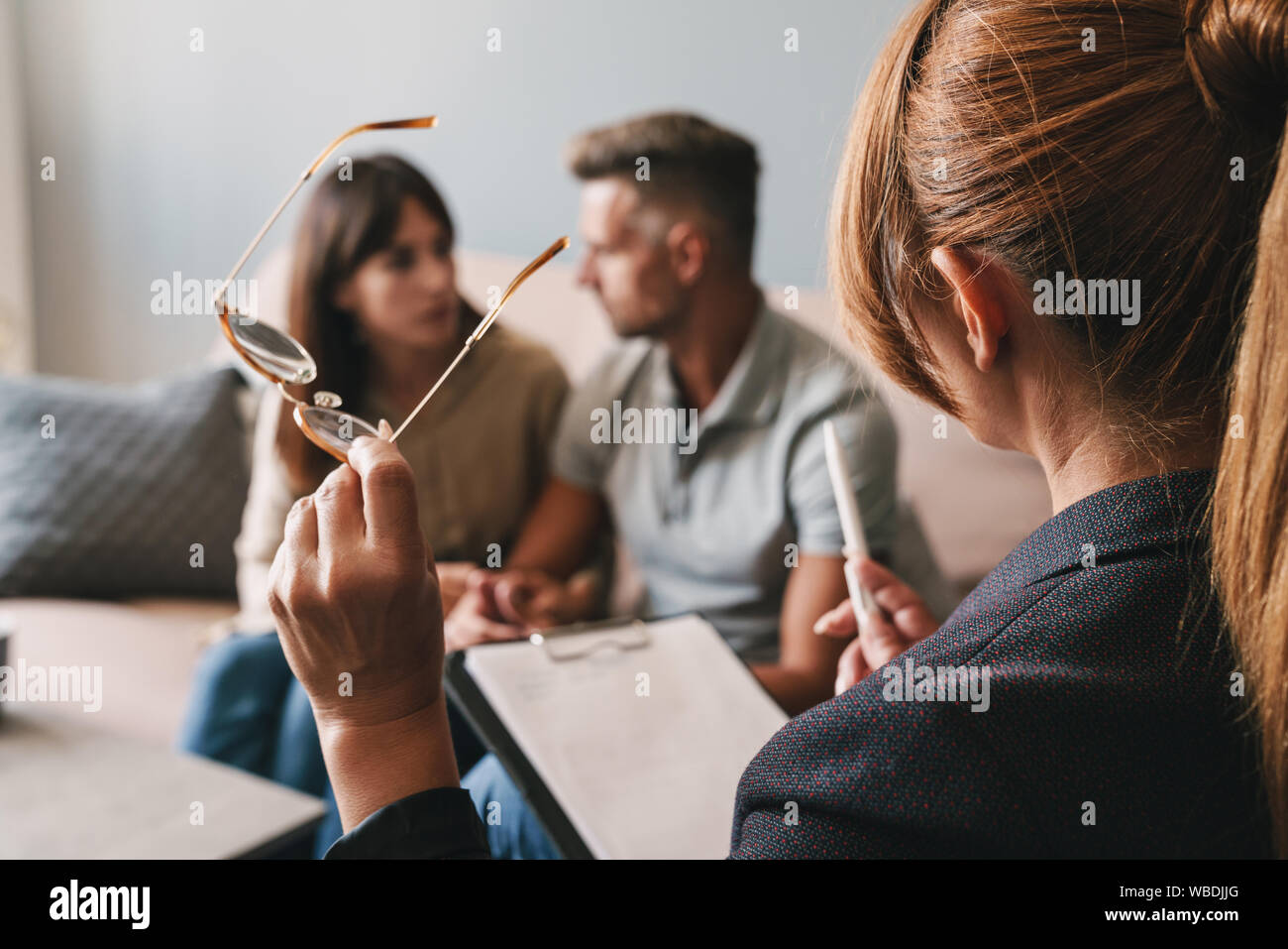 Photo de penser caucasian couple homme et femme d'avoir une conversation avec un psychologue sur séance de thérapie dans la chambre Banque D'Images