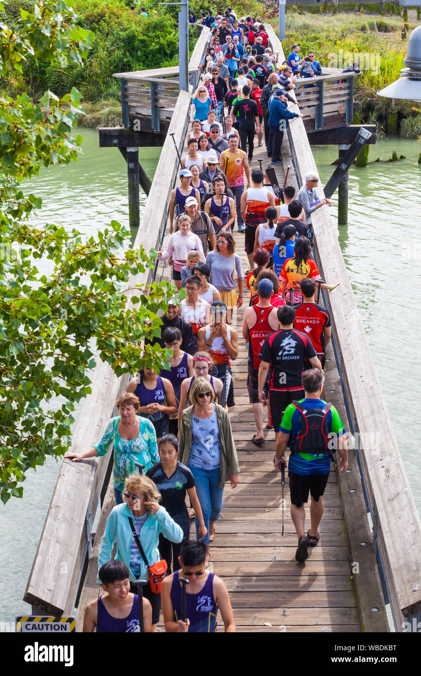 Les pagayeurs et spectateurs traversant une passerelle au Festival de bateau dragon de Steveston 2019 Colombie-Britannique Banque D'Images
