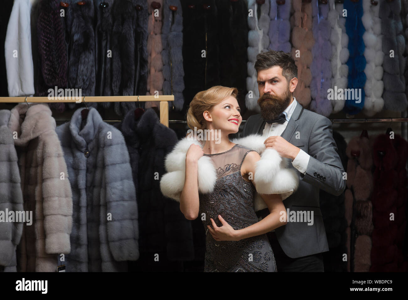 Femme en manteau de fourrure avec l homme shopping le vendeur et le client. Date couple l amour l homme et de la femme. Couple dans l amour entre les manteau de fourrure de luxe. Mode