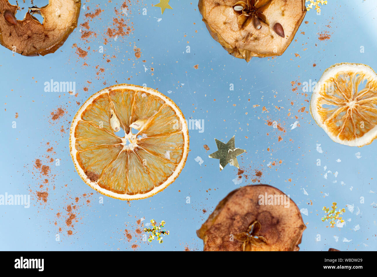 Cookies gingembre sec avec apple et les oranges en tranches et le bâton de cannelle volent sur un fond bleu. La Lévitation de l'alimentation. Concept de Noël Banque D'Images