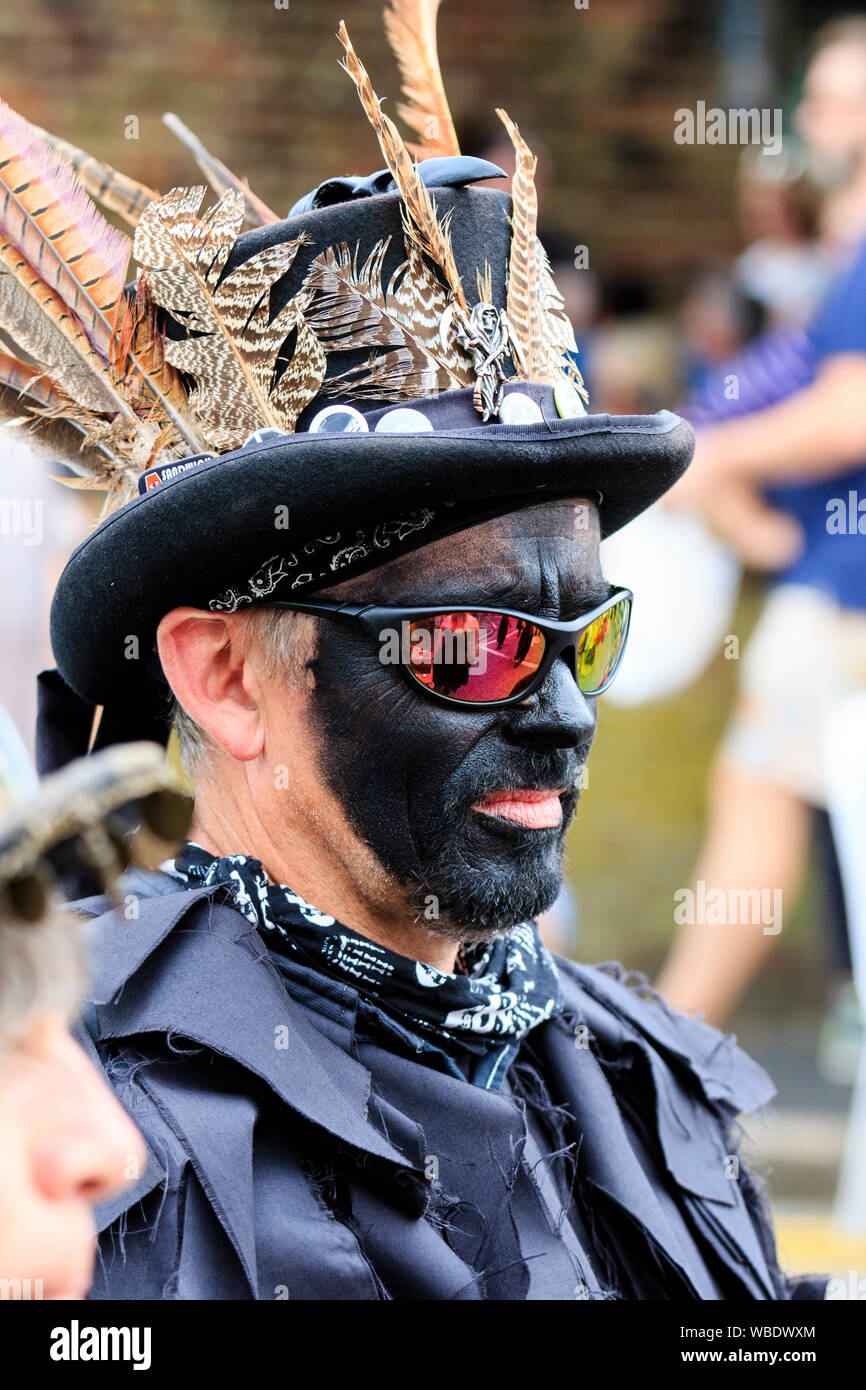 Folk Festival Ale et sandwich. Border morris danseur de la tête de loup du côté de Morris. Porter tout noir, lunettes de soleil et chapeau haut de forme, le visage noir. Banque D'Images