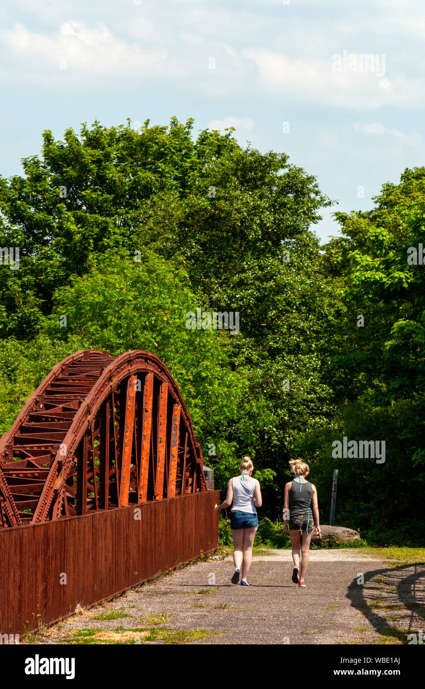 Deux jeunes femmes marchant sans soucis sur le vieux pont ferroviaire abandonné et abandonné Viaduc de Laune rouille sur la rivière Laune à Killorglin, dans le Colorado. Kerry, Irlande Banque D'Images