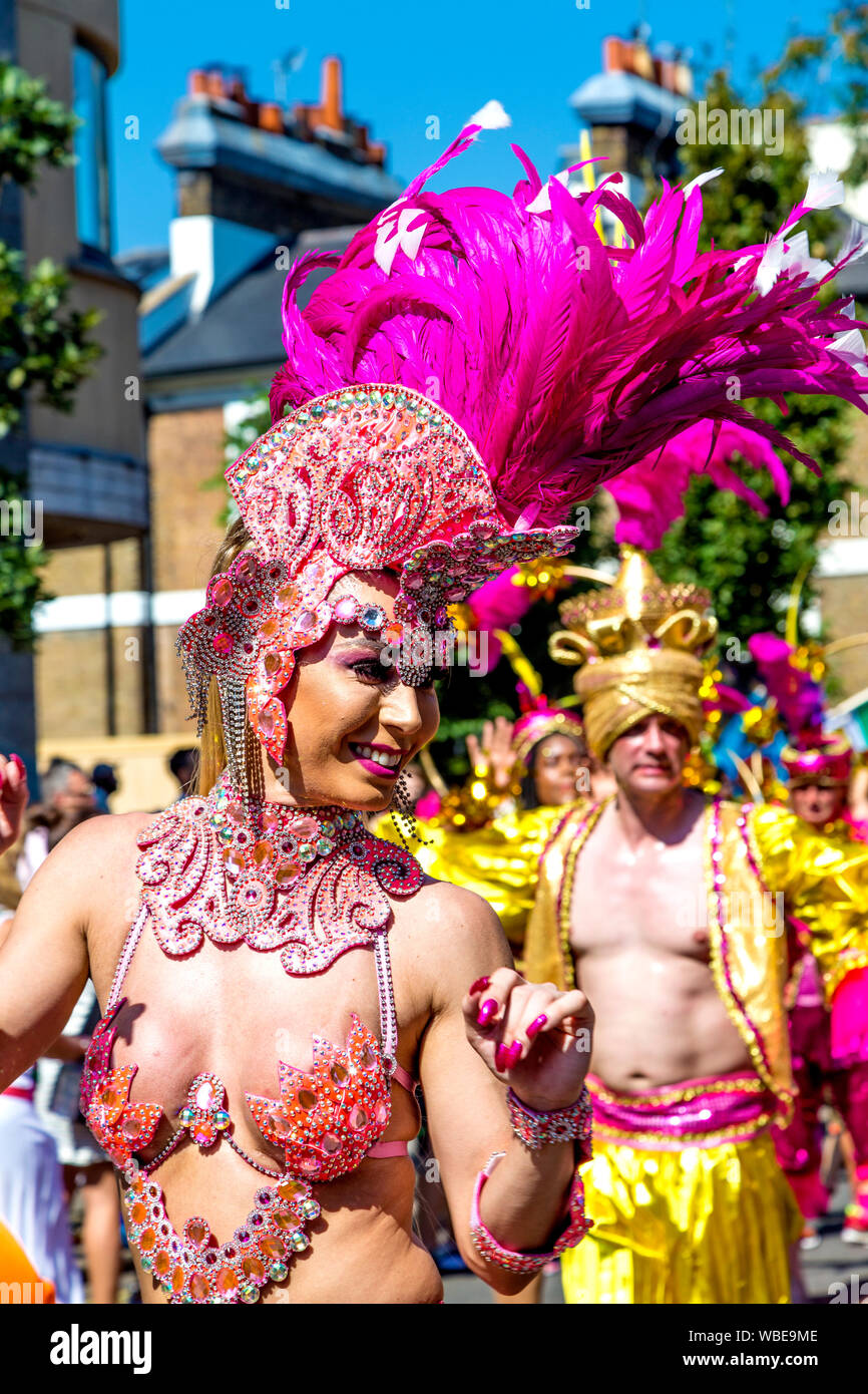 26 août 2019 - Femme avec une coiffure de grande plume danse de la parade, le carnaval de Notting Hill sur une maison de banque lundi, Londres, UK Banque D'Images