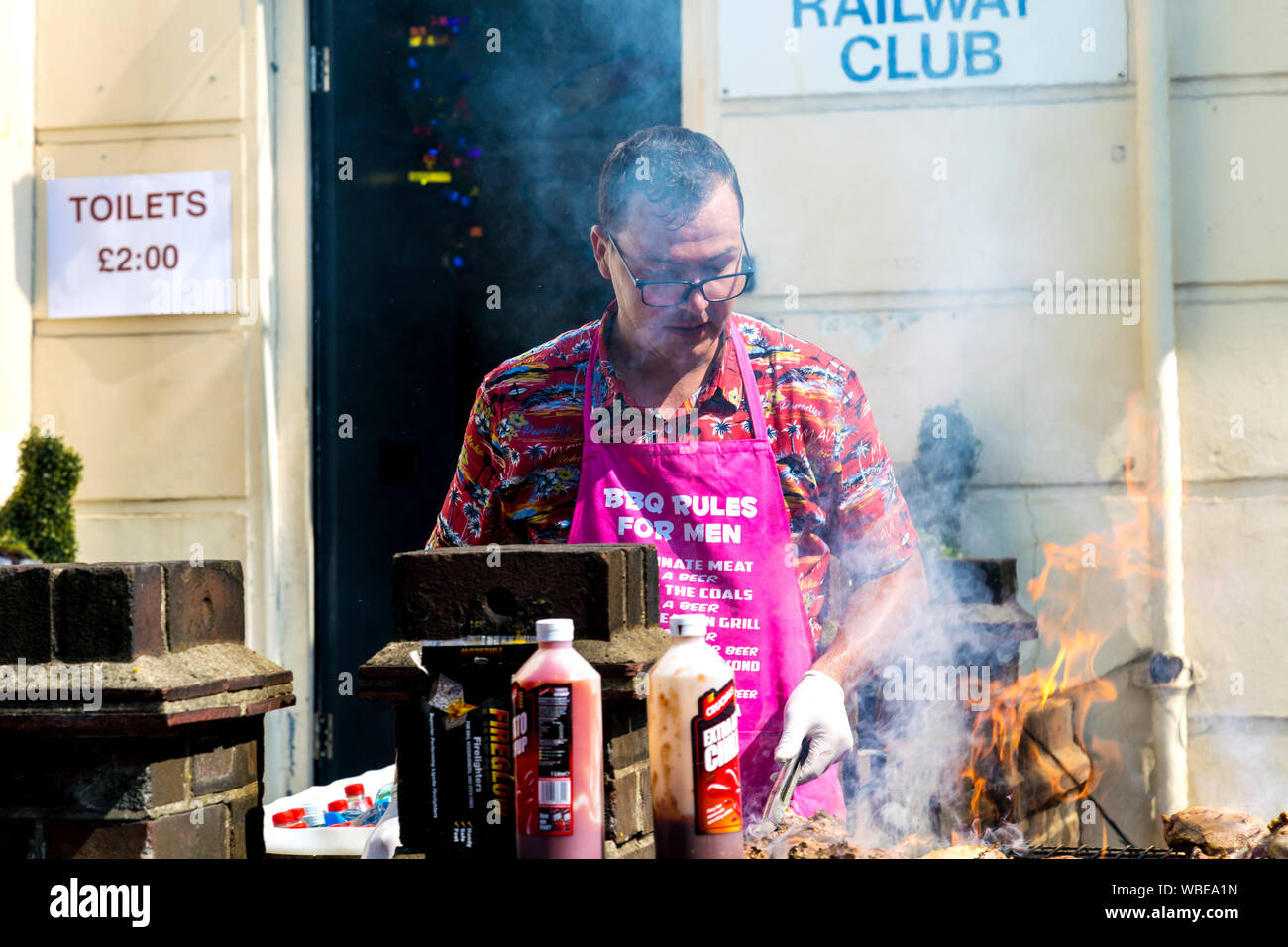 26 août 2019 - l'homme au barbecue la viande à une guérilla de fortune Poulet Jerk food, Notting Hill Carnival sur une banque chaud lundi férié, Londres, Royaume-Uni Banque D'Images