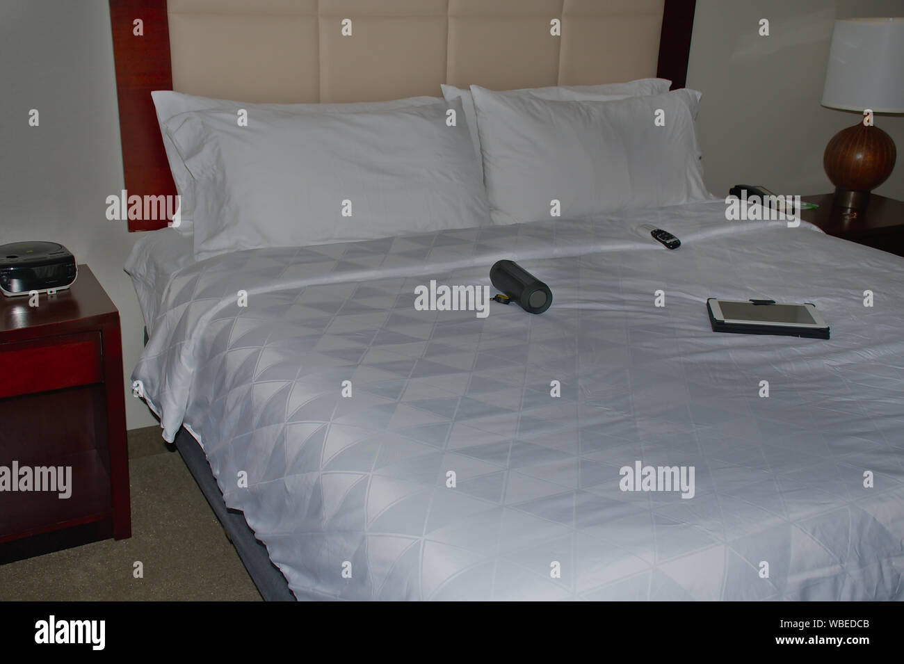 Voir l'hôtel de lit avec haut-parleurs portable électronique et électronique Pad et commande à distance Banque D'Images