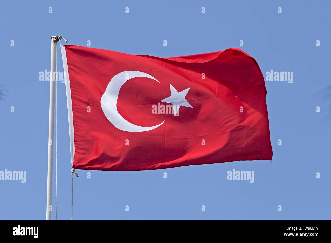 Brandissant le drapeau turc en face de ciel bleu, Turquie Banque D'Images