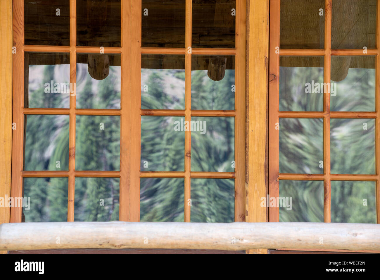 Arbres se reflétant dans la fenêtre d'une cabane à l'Minam River Lodge dans les montagnes de l'Oregon Wallowa. Banque D'Images