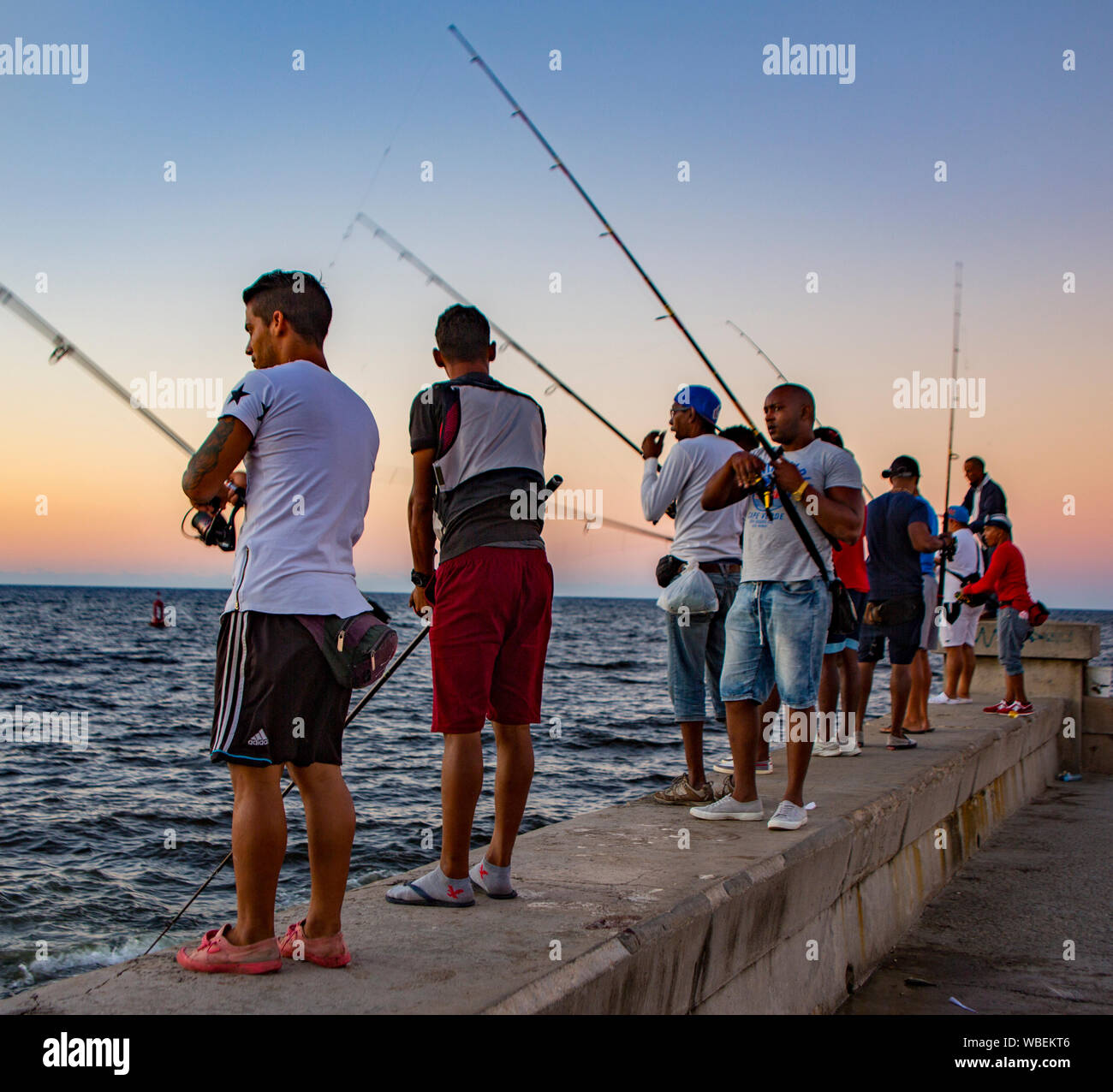 La Havane, Cuba - 19 novembre 2011 - Les jeunes hommes alignés sur un mur de béton pour les poissons de la baie Banque D'Images