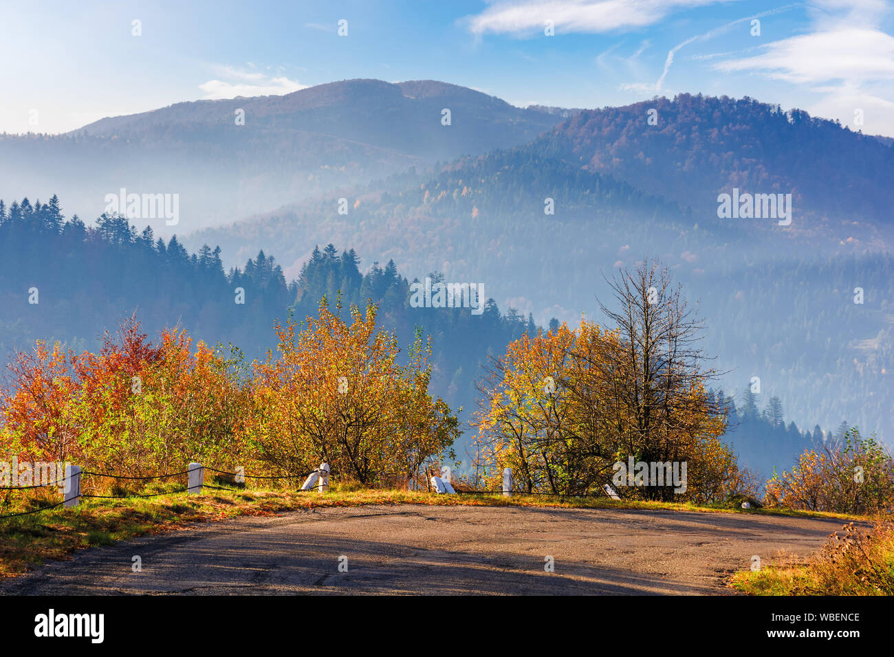 Vieille route serpentine en montagnes. beau décor de l'automne dans la lumière brumeuse du matin. superbe météo octobre avec des nuages sur le ciel. ridge dans t Banque D'Images