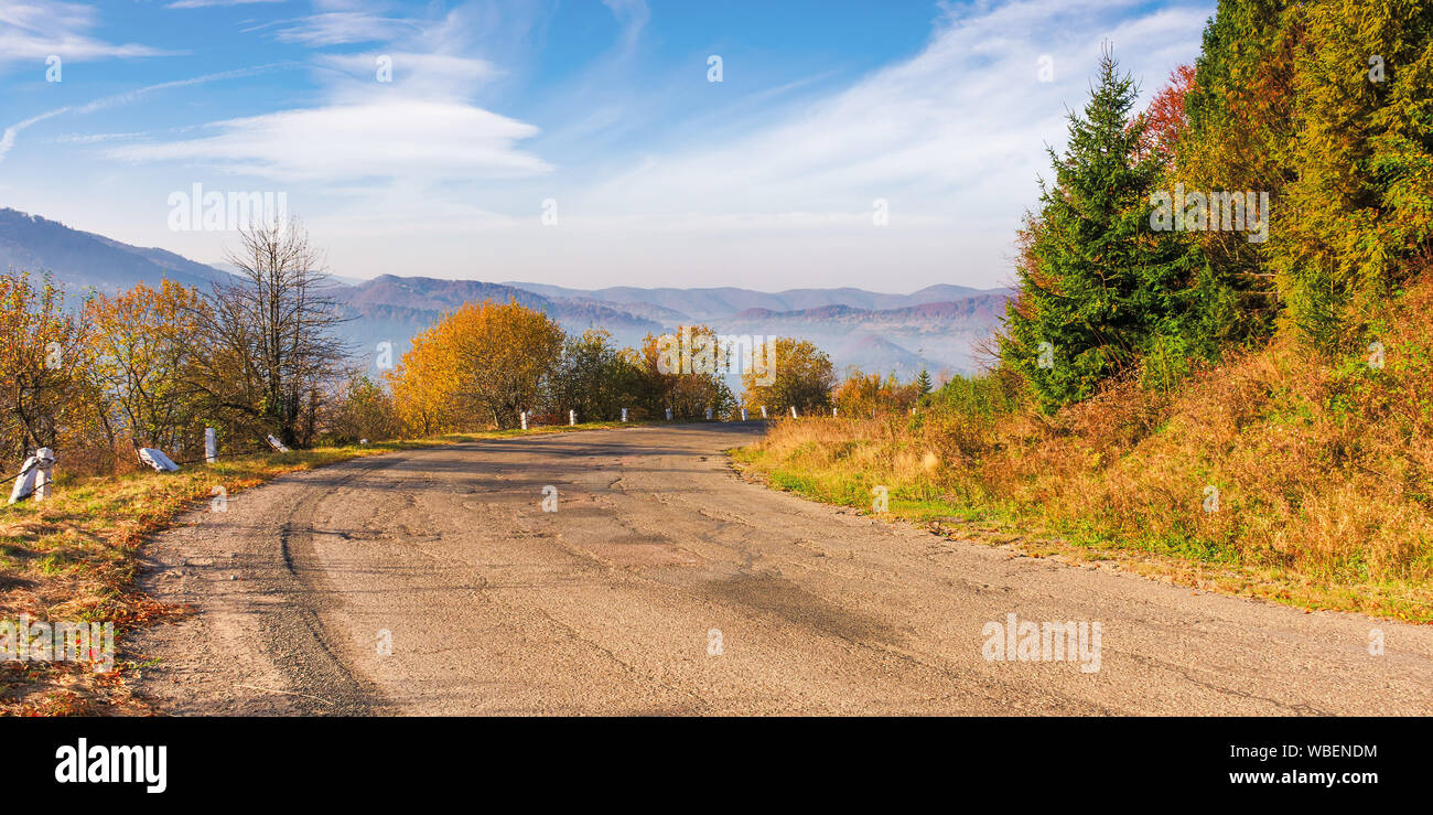 Vieille route serpentine en montagnes. beau décor de l'automne dans la lumière brumeuse du matin. superbe météo octobre avec des nuages sur le ciel. ridge dans t Banque D'Images