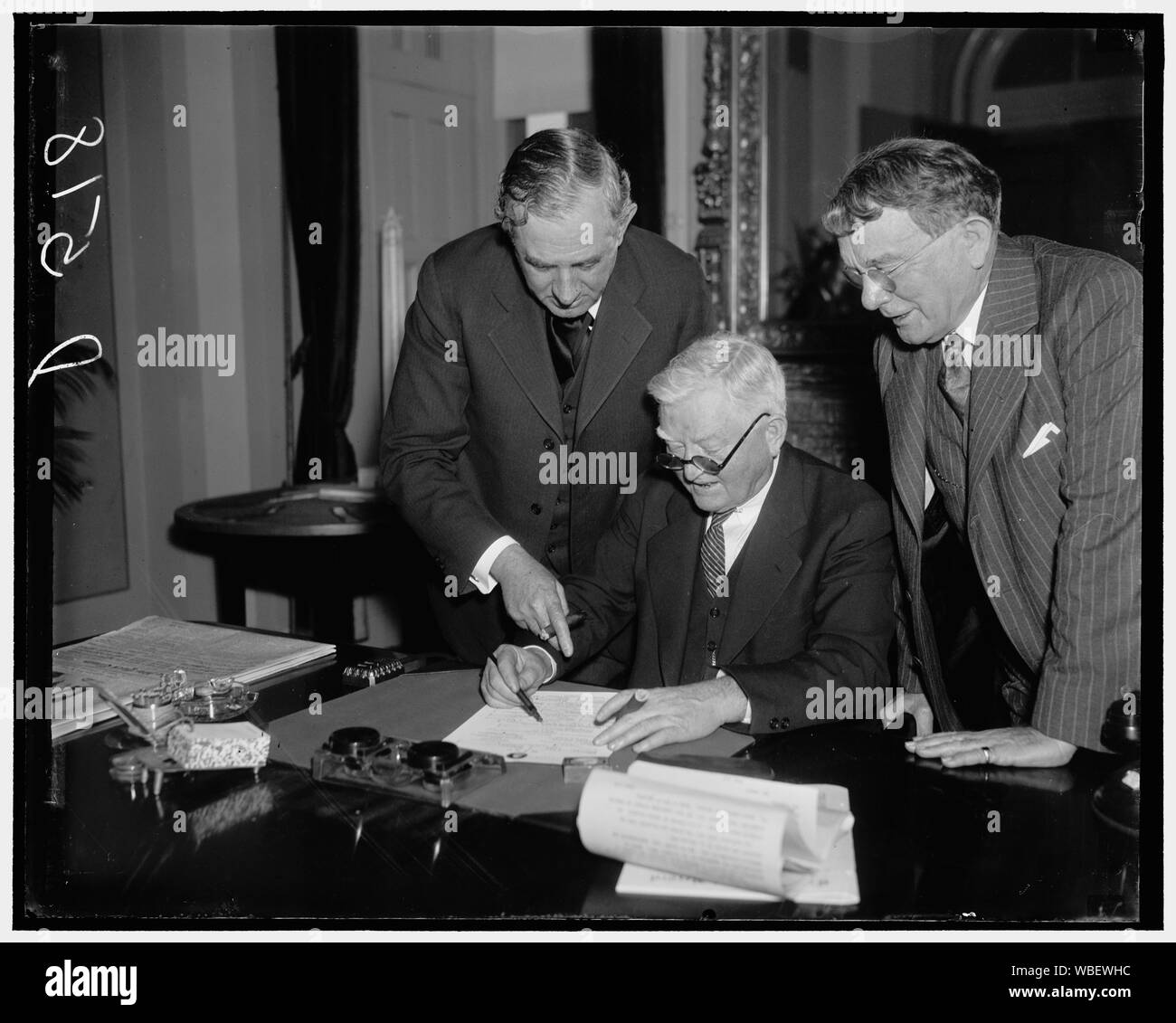 Garner signe le projet de loi de neutralité. Washington, D.C., le 8 janvier. Enfin le Vice-président a signé la loi de neutralité qui a été suspens depuis quelques jours parce que des expéditions tous prêts à aller en Espagne à travers quelques tie-up parlementaire du vice-président ont dû attendre 24 heures avant qu'il puisse le signer et le présenter à la Maison Blanche pour la signature du président Roosevelt. Photo, de gauche à droite : le sénateur Tom Connally du Texas ; Vice-président Garner ; et le sénateur Kenneth McKellar de Tenn. Abstract/moyenne : 1 négatif : vitrage ; 4 x 5 in. ou moins Banque D'Images