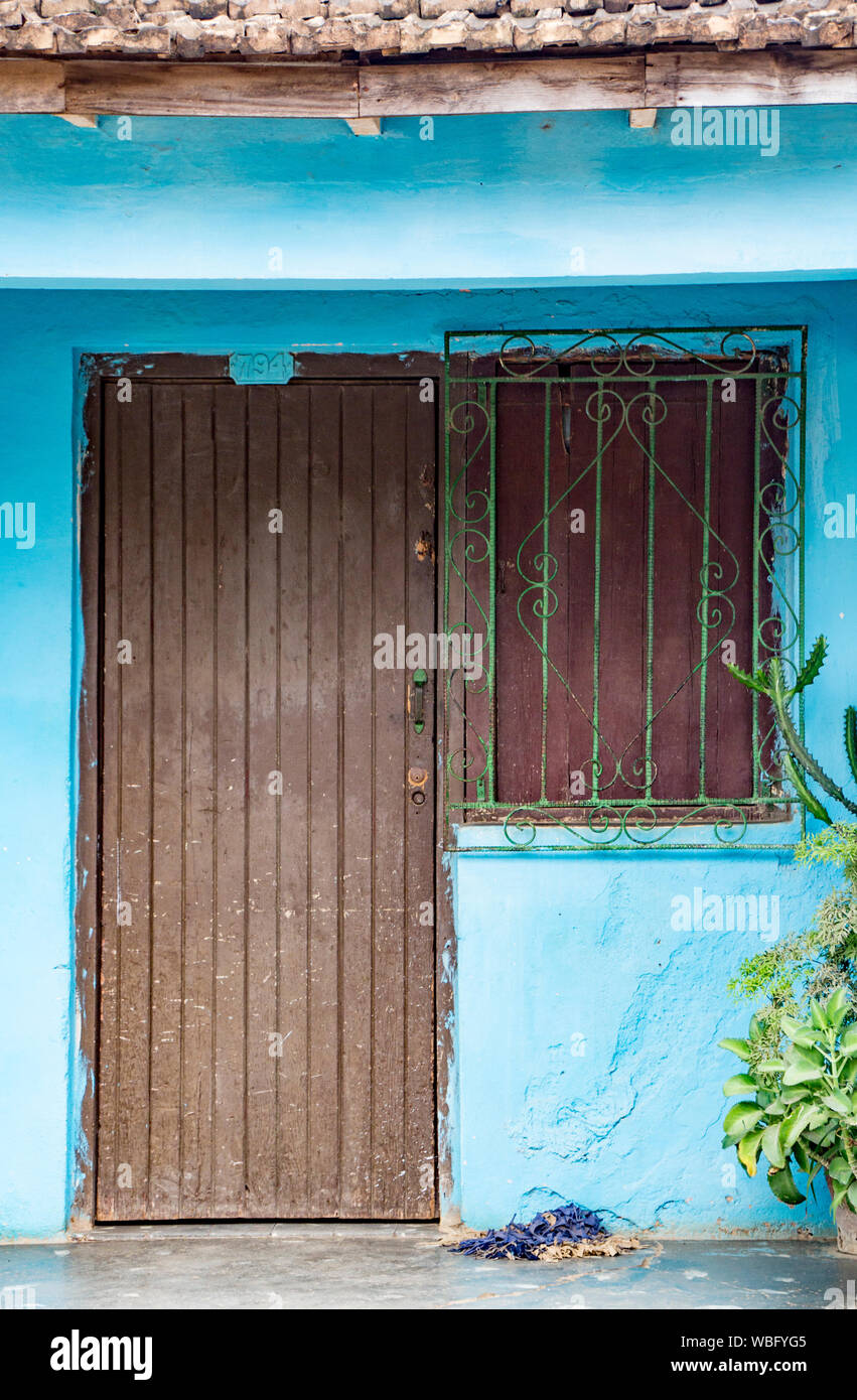 Trinidaad, Cuba 26 Nov 2017 - Brown porte et fenêtre sur mur bleu râpé Banque D'Images