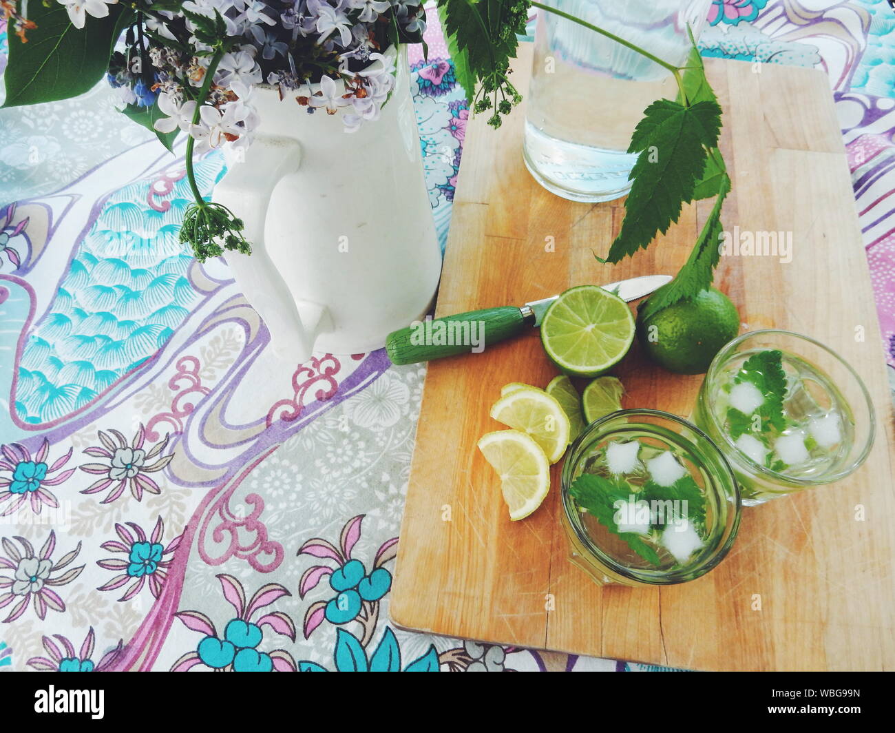 Portrait de Mojito sur une planche à découper par Vase à fleurs sur table Banque D'Images