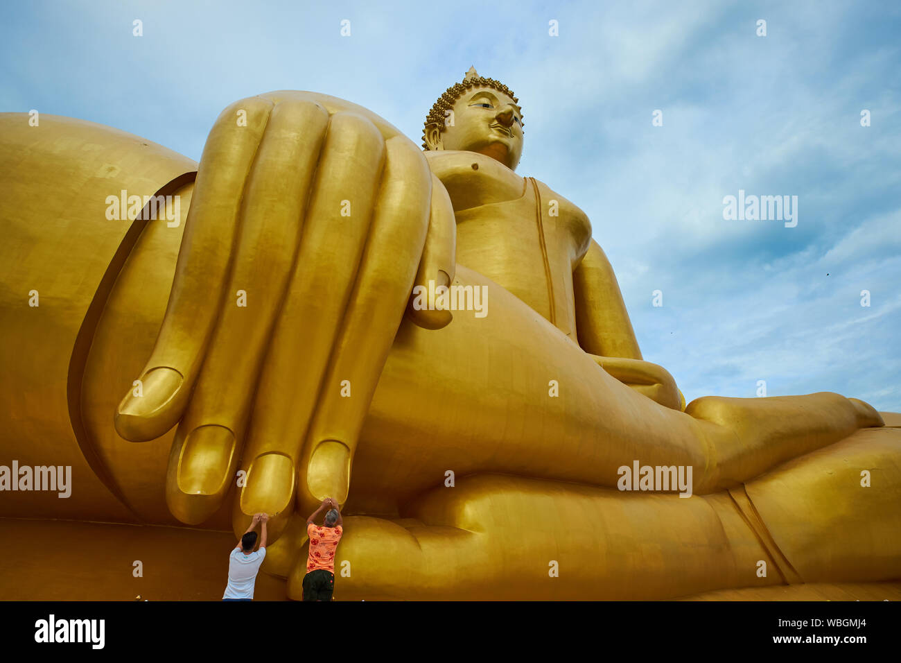 Vue grand angle d'un géant, d'or, assis Bouddha à Wat Muang dans Ang Thong, en Thaïlande. Les fidèles sont en contact avec ses doigts. Banque D'Images