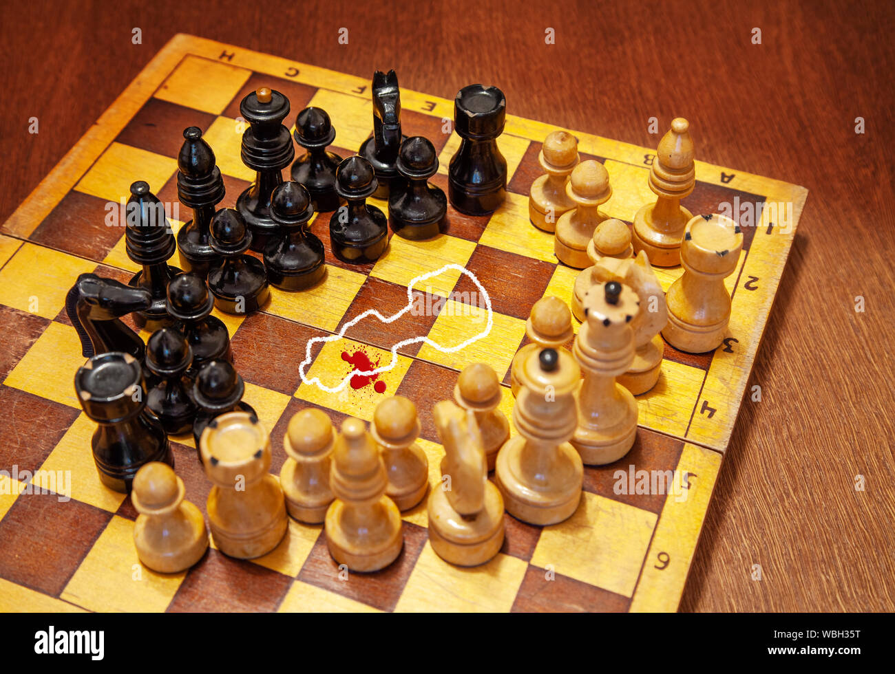 Pièces des échecs debout autour et regardez la silhouette de craie sur le corps avec du sang sur un échiquier Banque D'Images