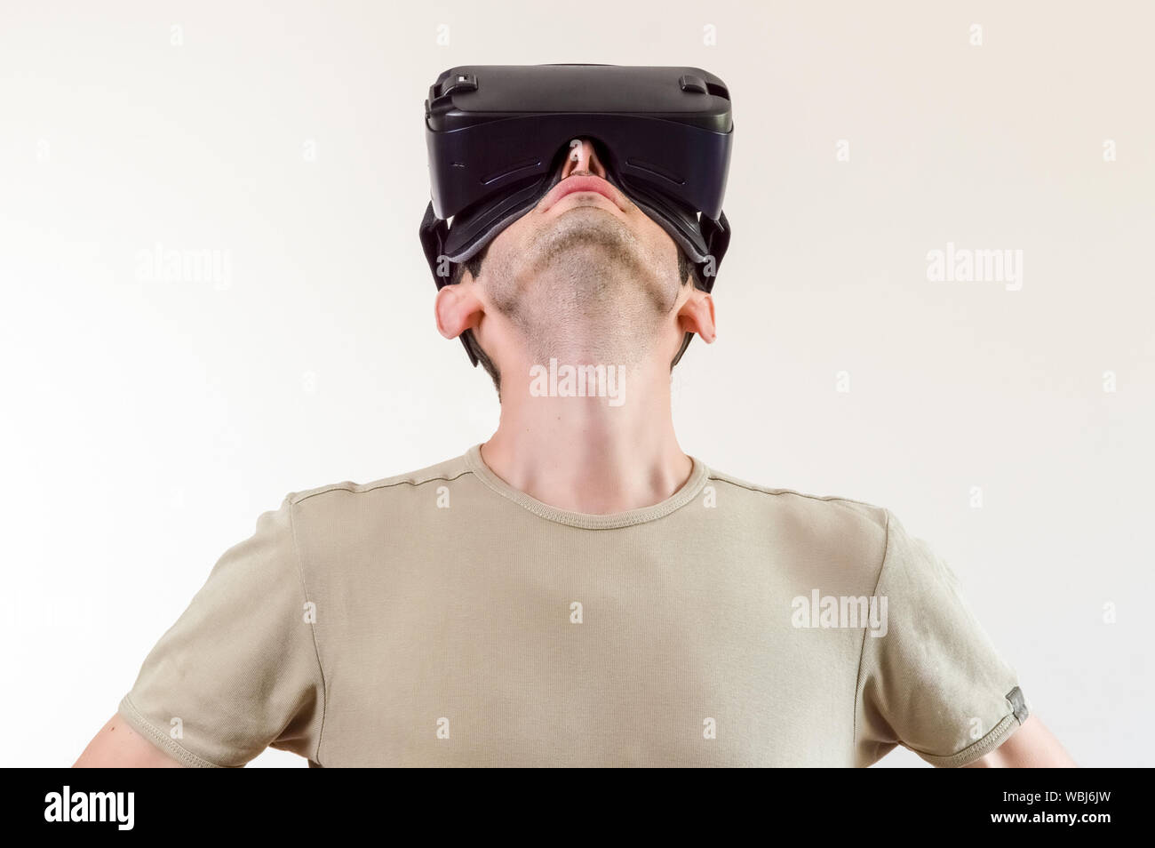 Man dans t-shirt portant des lunettes de réalité virtuelle sur fond blanc. La future technologie concept. Banque D'Images