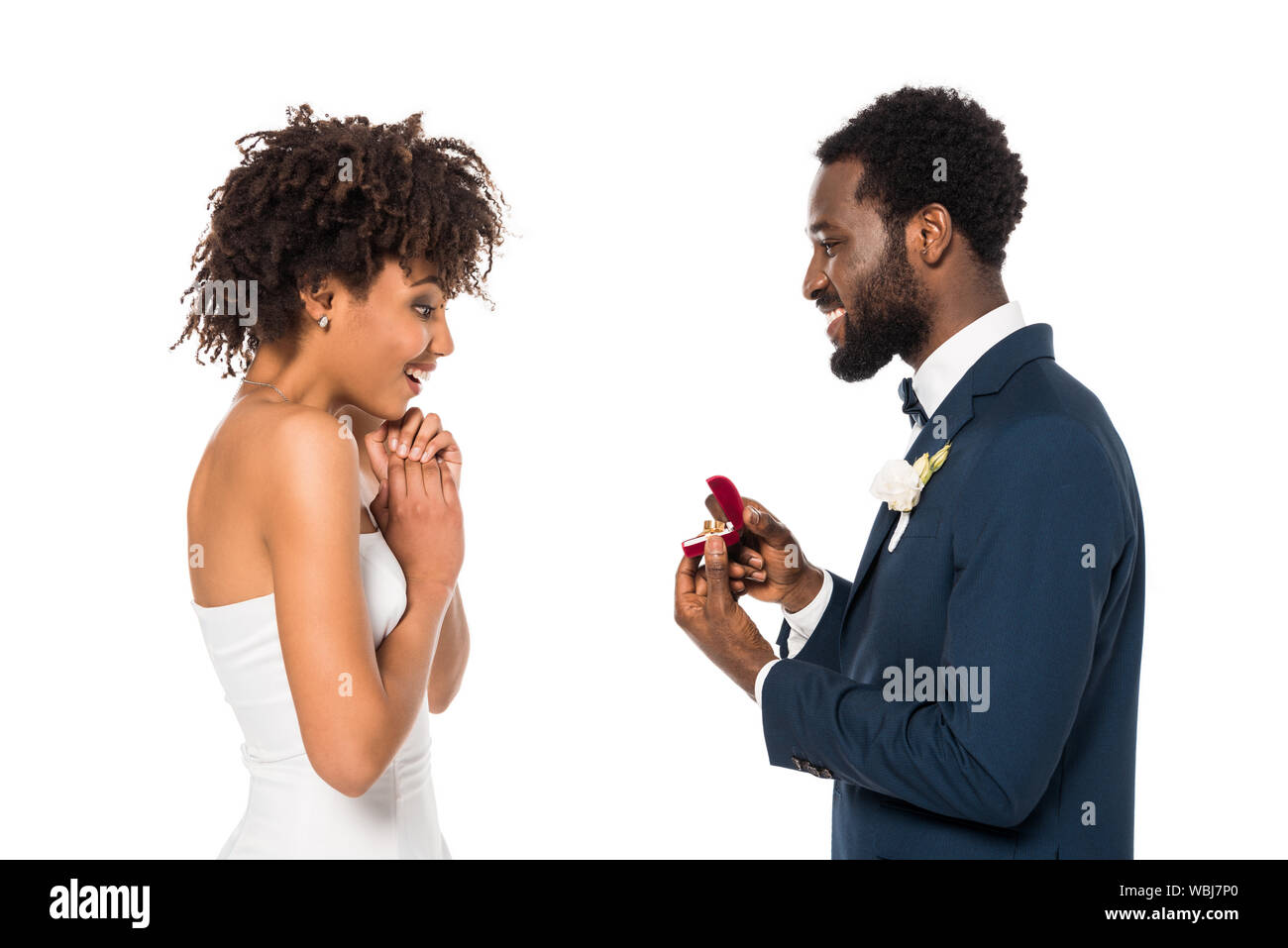 African American man holding box avec bague tout en proposition d'surprised woman isolated on white Banque D'Images