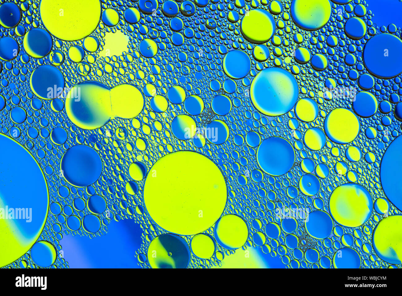 Motifs de bulles multicolores formés par l'huile flottant sur l'eau Banque D'Images