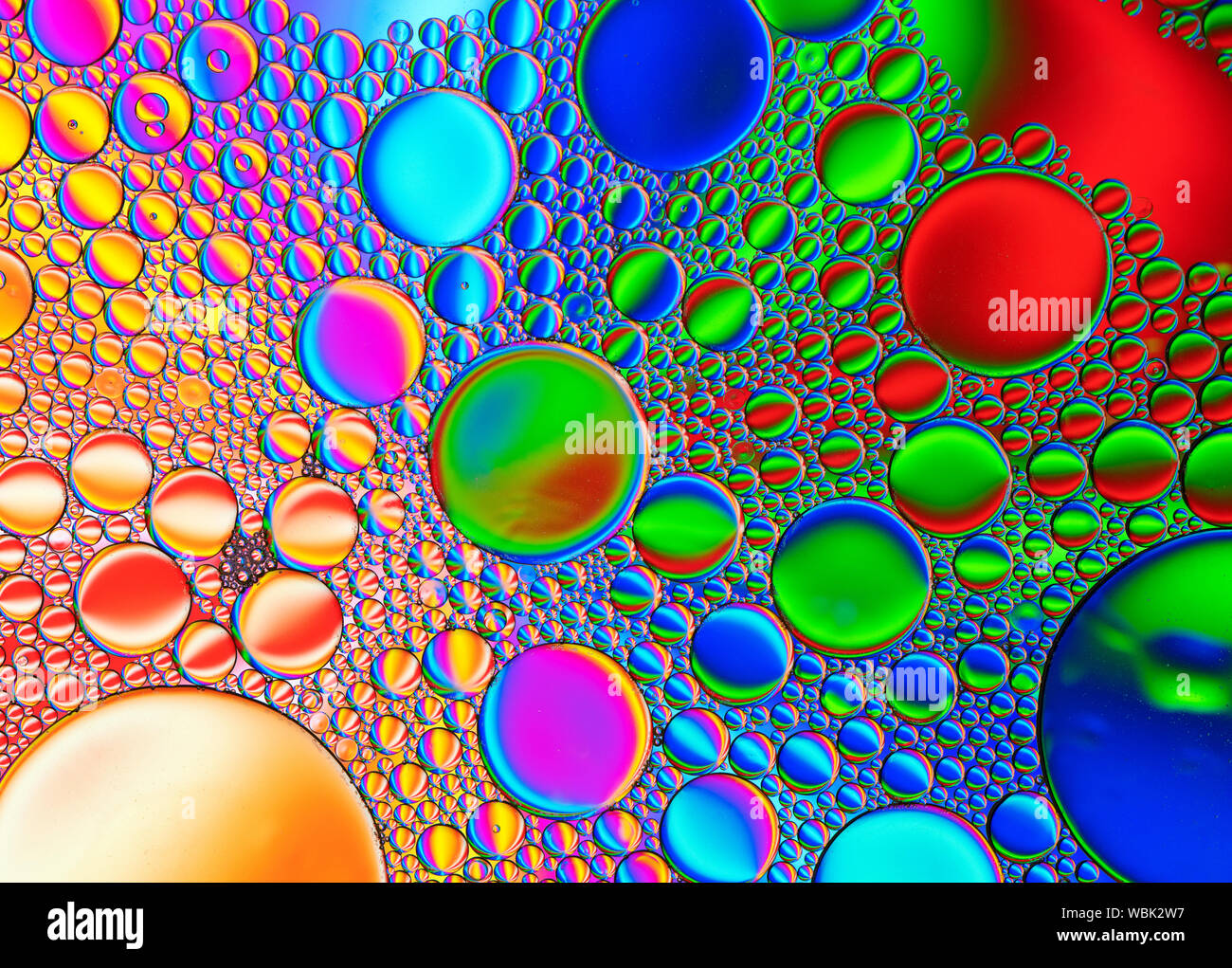 Motifs de bulles multicolores formés par l'huile flottant sur l'eau Banque D'Images