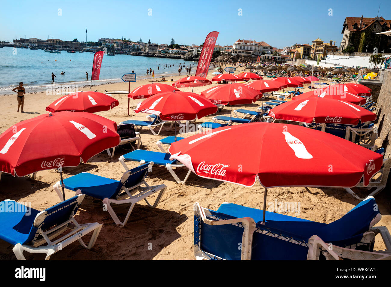 La marque Coca Cola des chaises longues et des parasols sur la plage de Cascais, Portugal. Banque D'Images